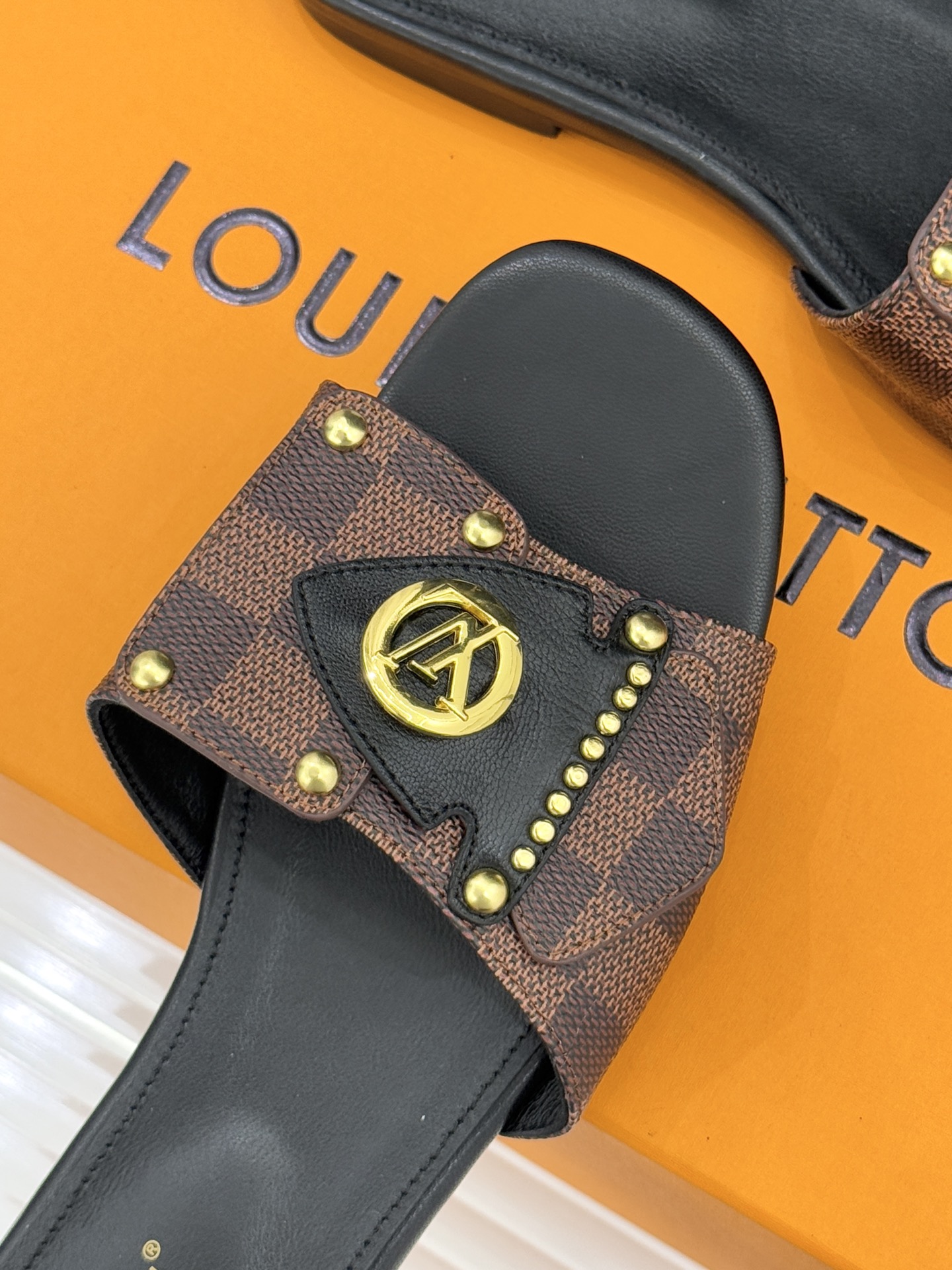 L*V驴家经典老花金属扣平底拖鞋以标志性老花皮革勾勒优雅轮廓意大利匠心工艺凝萃百年奢韵。亮眼金色金属扣镌