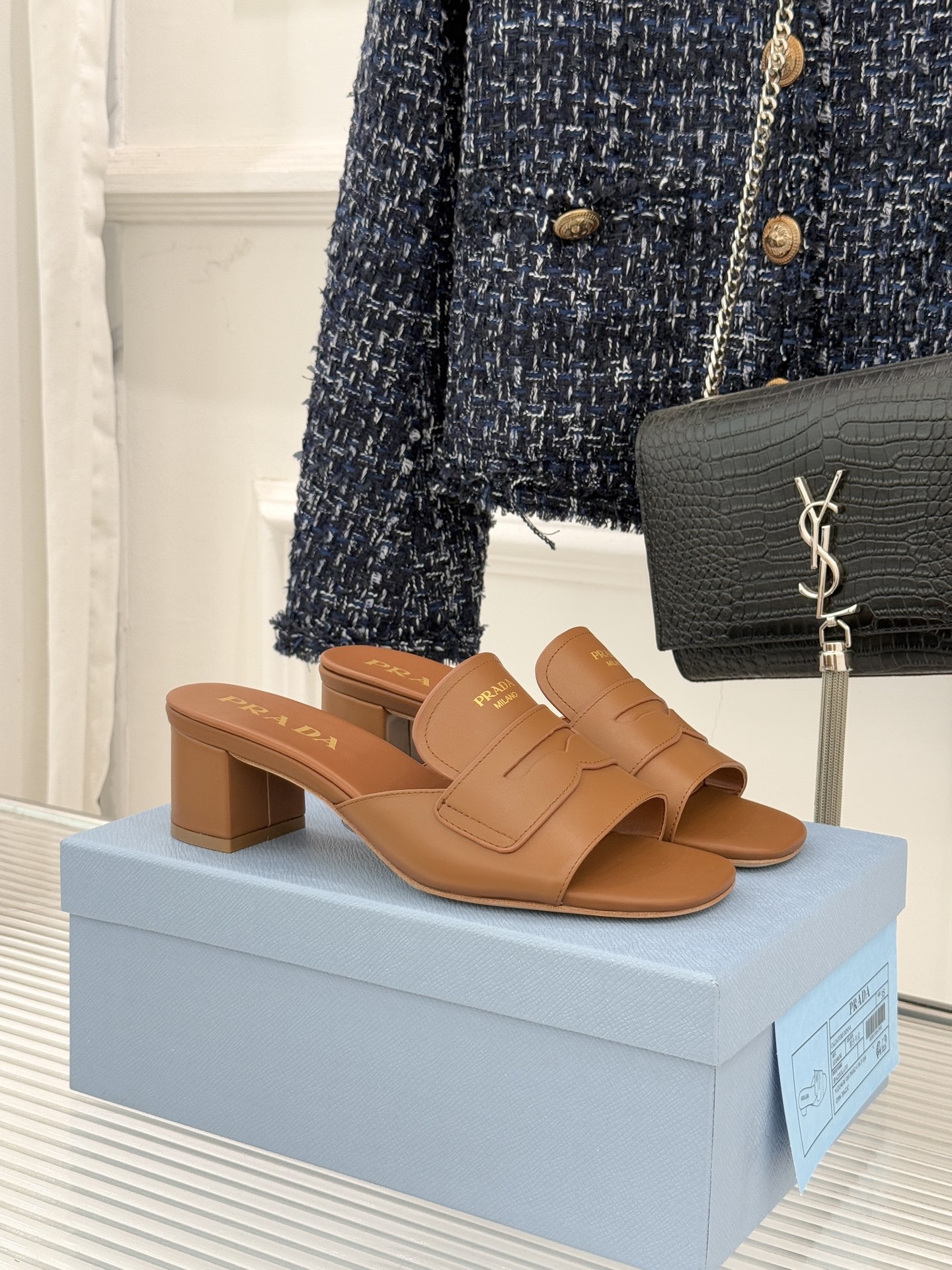 Prada/普拉达经典极简字母粗跟拖鞋循“基调之变”的设计哲思这双跟拖鞋解构奢华本质。以利落线条勾勒锥形