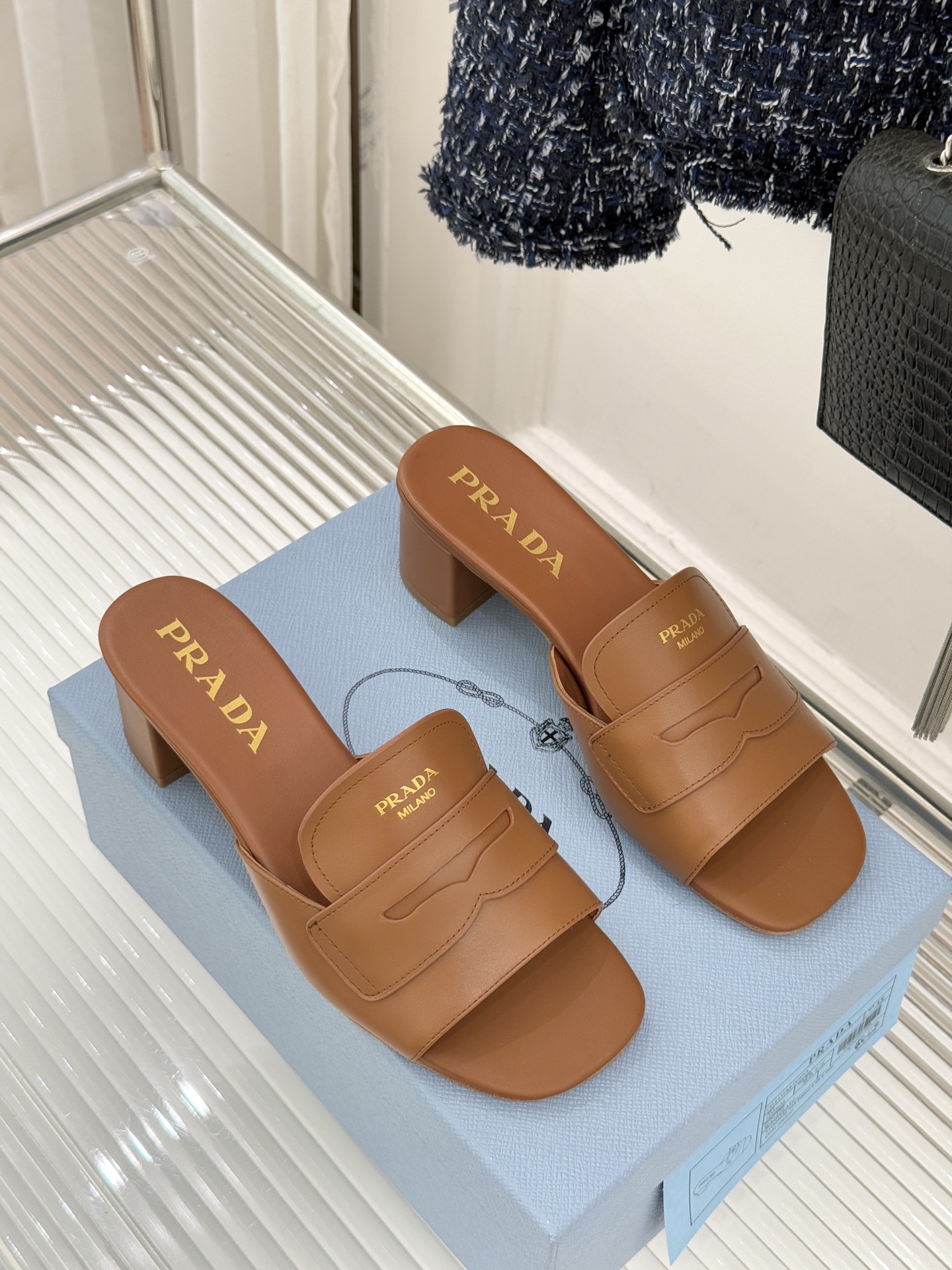 Prada/普拉达经典极简字母粗跟拖鞋循“基调之变”的设计哲思这双跟拖鞋解构奢华本质。以利落线条勾勒锥形
