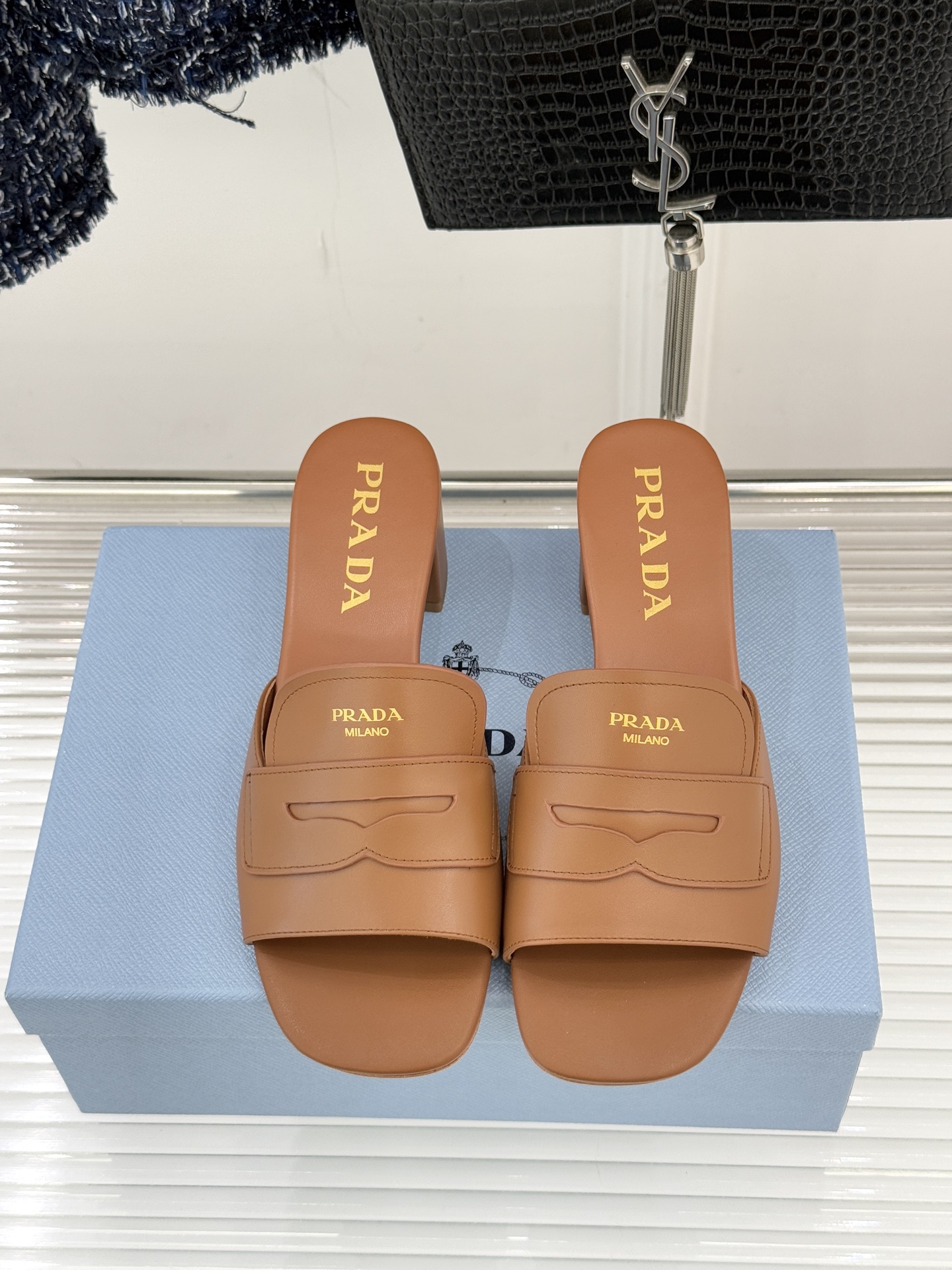 Prada/普拉达经典极简字母粗跟拖鞋循“基调之变”的设计哲思这双跟拖鞋解构奢华本质。以利落线条勾勒锥形