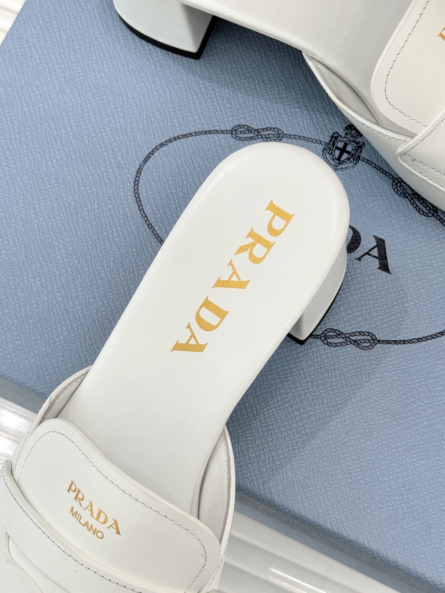 Prada/普拉达经典极简字母粗跟拖鞋循“基调之变”的设计哲思这双跟拖鞋解构奢华本质。以利落线条勾勒锥形