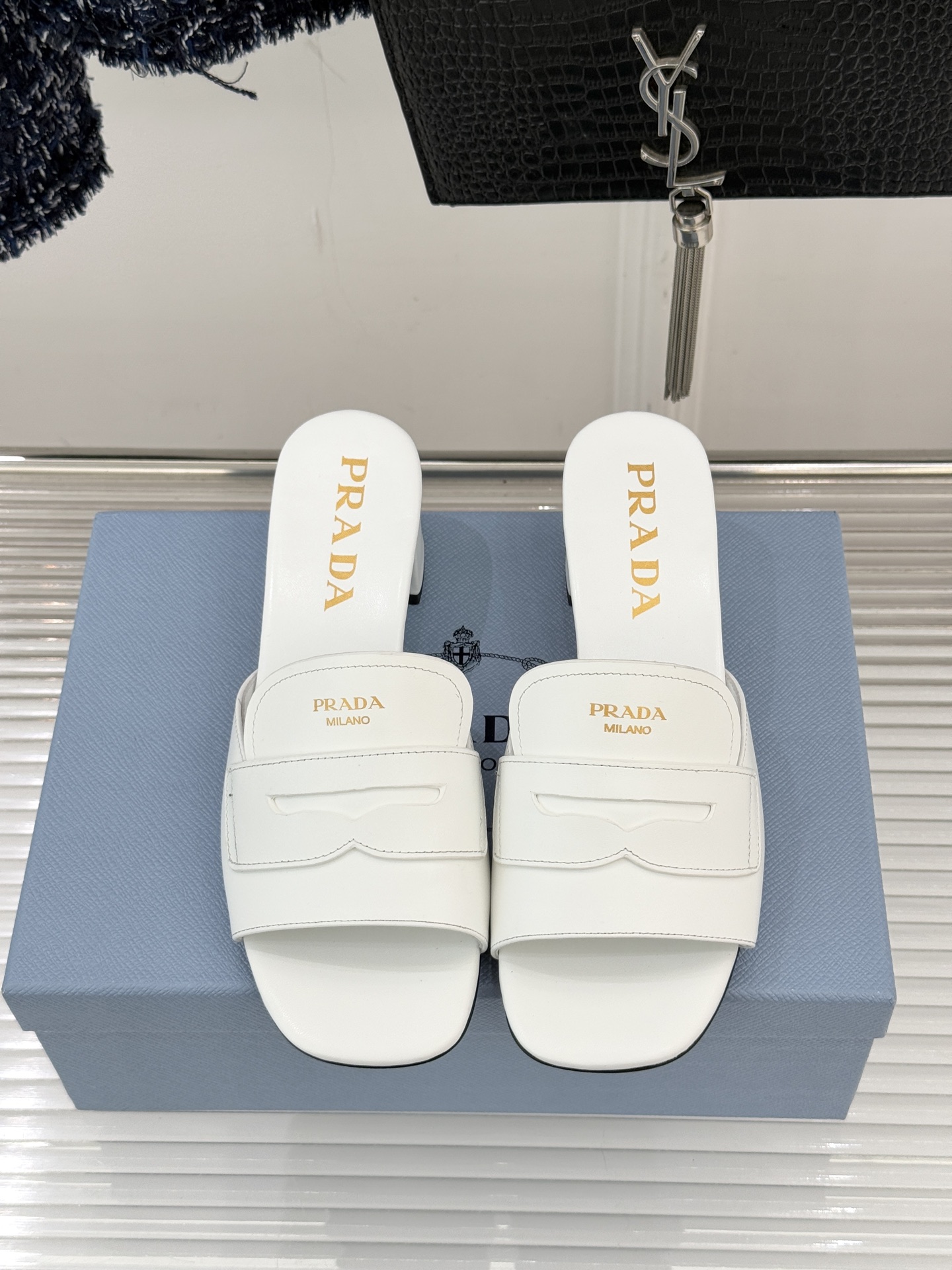 Prada/普拉达经典极简字母粗跟拖鞋循“基调之变”的设计哲思这双跟拖鞋解构奢华本质。以利落线条勾勒锥形