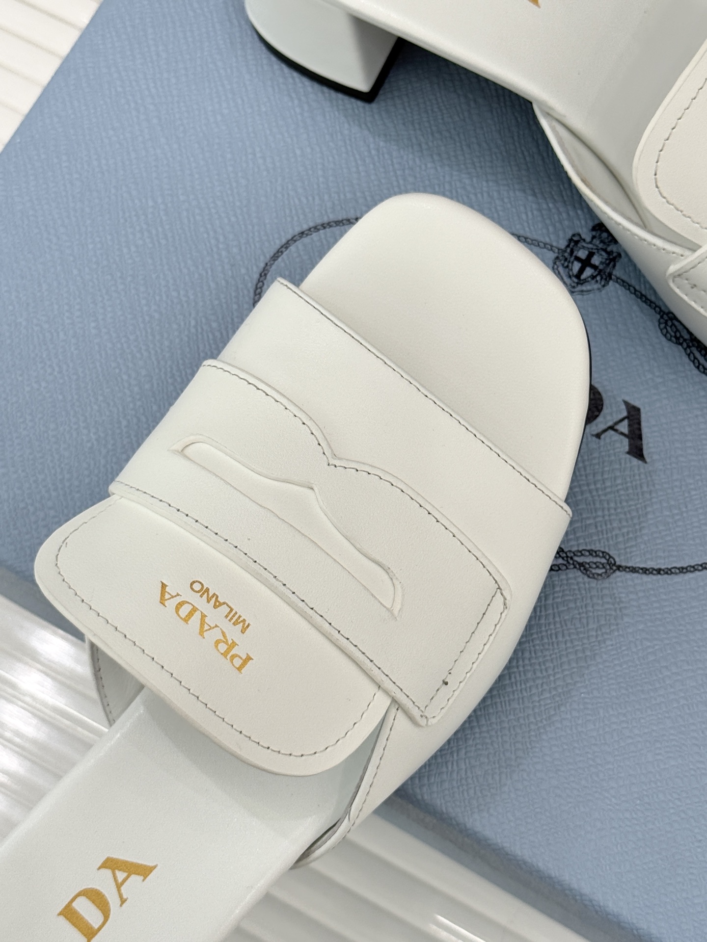 Prada/普拉达经典极简字母粗跟拖鞋循“基调之变”的设计哲思这双跟拖鞋解构奢华本质。以利落线条勾勒锥形