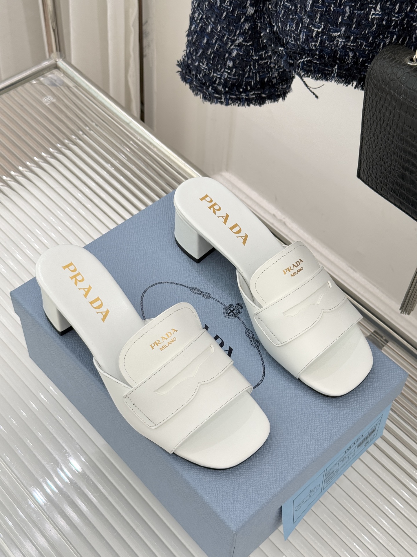 Prada/普拉达经典极简字母粗跟拖鞋循“基调之变”的设计哲思这双跟拖鞋解构奢华本质。以利落线条勾勒锥形