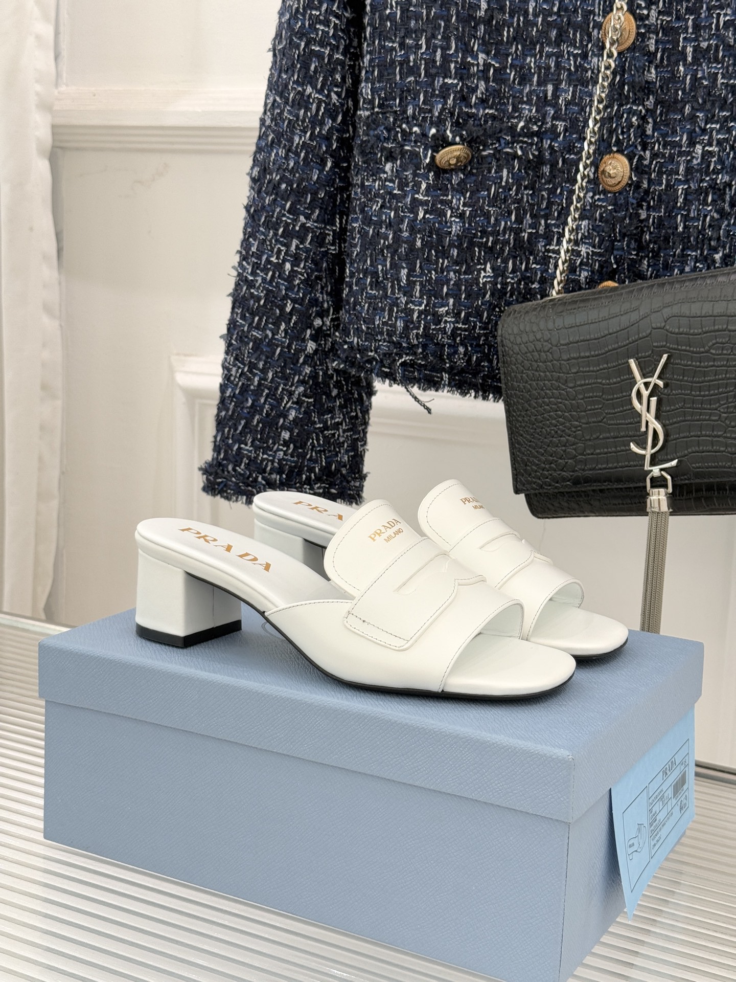 Prada/普拉达经典极简字母粗跟拖鞋循“基调之变”的设计哲思这双跟拖鞋解构奢华本质。以利落线条勾勒锥形