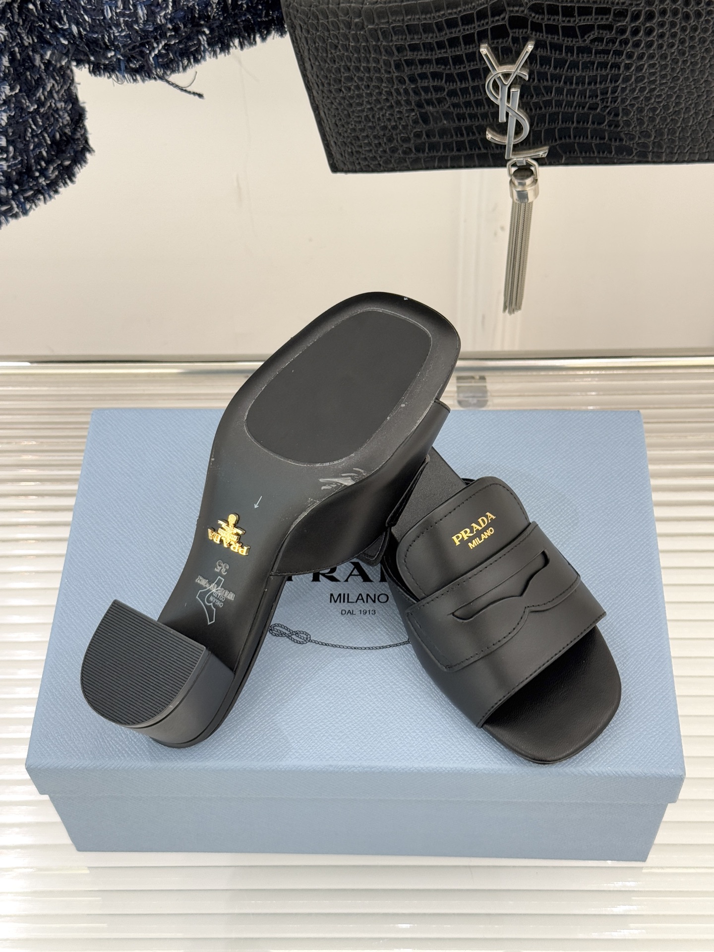 Prada/普拉达经典极简字母粗跟拖鞋循“基调之变”的设计哲思这双跟拖鞋解构奢华本质。以利落线条勾勒锥形