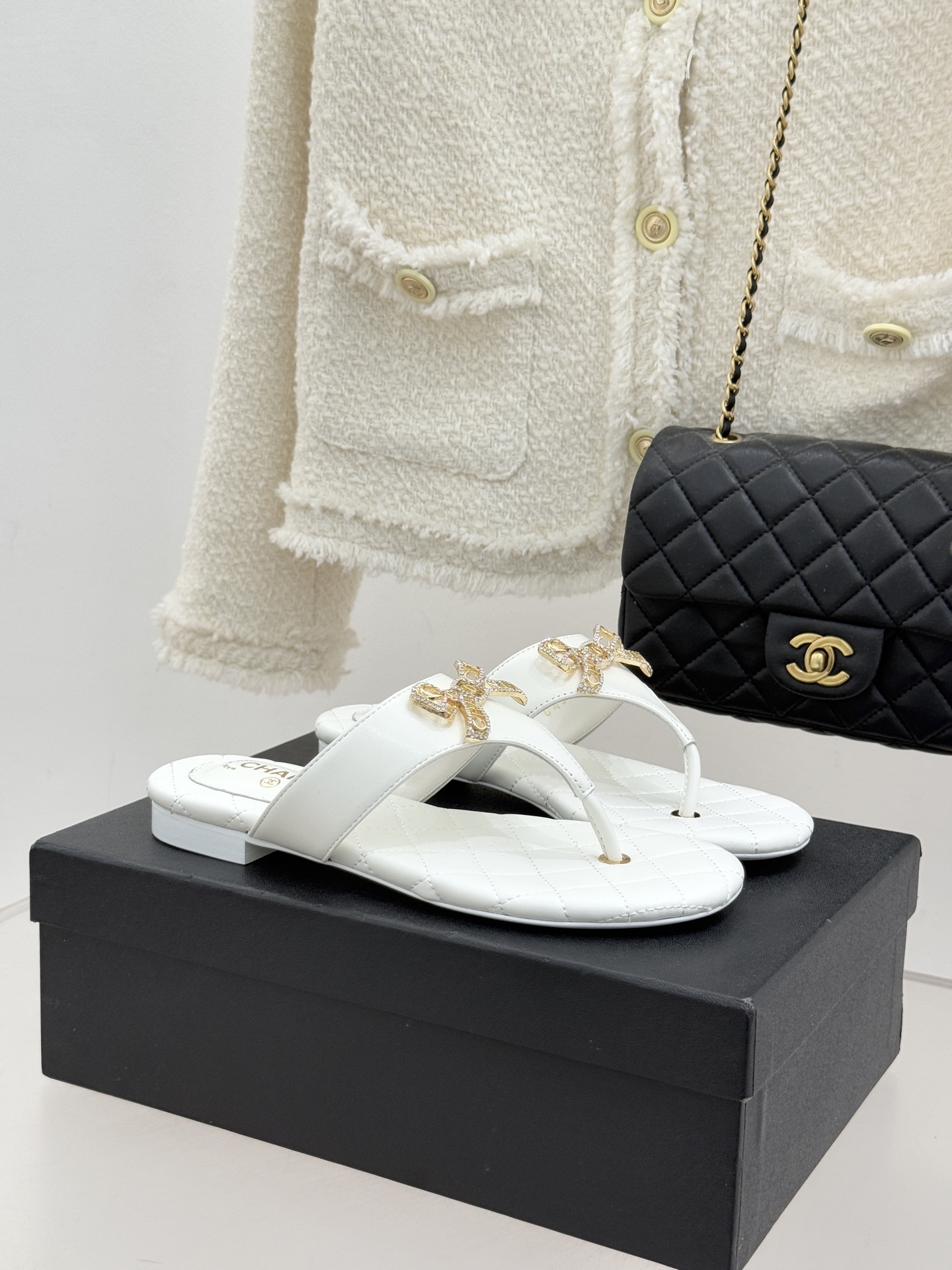 NO:726244,CHANE*｜Xiaoxiang Classic Rhinestone Double C Bow Flat Flip-Flop Slippers When the classic rhinestone Double C meets the smart metal bow, this pair of slippers has become synonymous with elegance and sweetness. The metal bow is studded with bright rhinestones and the double C logo hidden in the middle reflects the tiny starlight under the light. Every step brings unintentional sparkle. The slender cat heel subtly lengthens the leg line and modifies the proportion without the constraint of high heels.  It is an ideal choice for daily commuting and leisure travel. Whether it is paired with nine-point jeans to create a casual style or worn with a satin dress to attend a light luxury party, it can stand out with its detailed texture and show the eternal charm of the small fragrance. The fabric is made of original customized leather, the inner pads are all lambskin, and the genuine leather outsole imported from Italy size35-39 (customized for 40/41) No. 84920260225, split-toe shoes, chanel, high  heels,slippers,skirts,jeans,sheepskin,Leather soles19860909CHANE*｜小香经典水钻双C蝴蝶结 平底夹脚人字拖鞋 当经典水钻双C遇上灵动金属蝴蝶结 这双拖鞋便成了优雅与甜美的代名词 金属蝴蝶结缀满璀璨水钻 中间暗藏的双C标识 在光线下折射出细碎星光 每一步都带着不刻意的闪耀. 纤细猫跟巧妙拉长腿部线条 修饰比例却无高跟鞋的束缚感 堪称日常通勤与休闲出行的理想之选. 无论是搭配九分牛仔裤打造随性格调 还是配缎面连衣裙出席轻奢派对 都能凭借细节质感脱颖而出 尽显小香风的永恒魅力. 面料采用原版定制皮料 内里垫脚均为小羊皮 意大利进口真皮大底 size35-39（40/41定制） 编号84920260225,分趾鞋,chanel,high heels,slippers,skirts,jeans,sheepskin,Leather soles,Women's Shoes