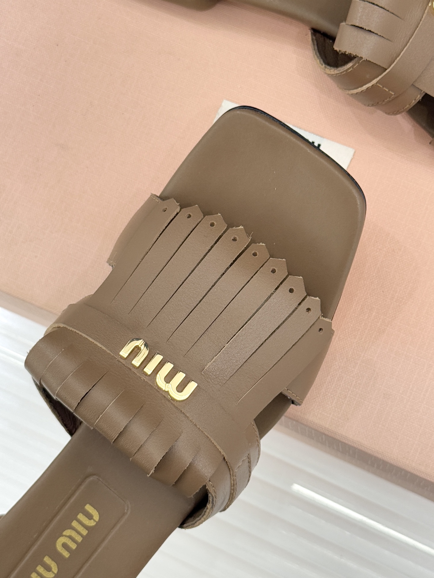 Miu Miu/缪缪26WF早春新品字母流苏猫跟拖鞋将灵动少女感与轻奢格调完美融合。鞋面饰有品牌字母标识