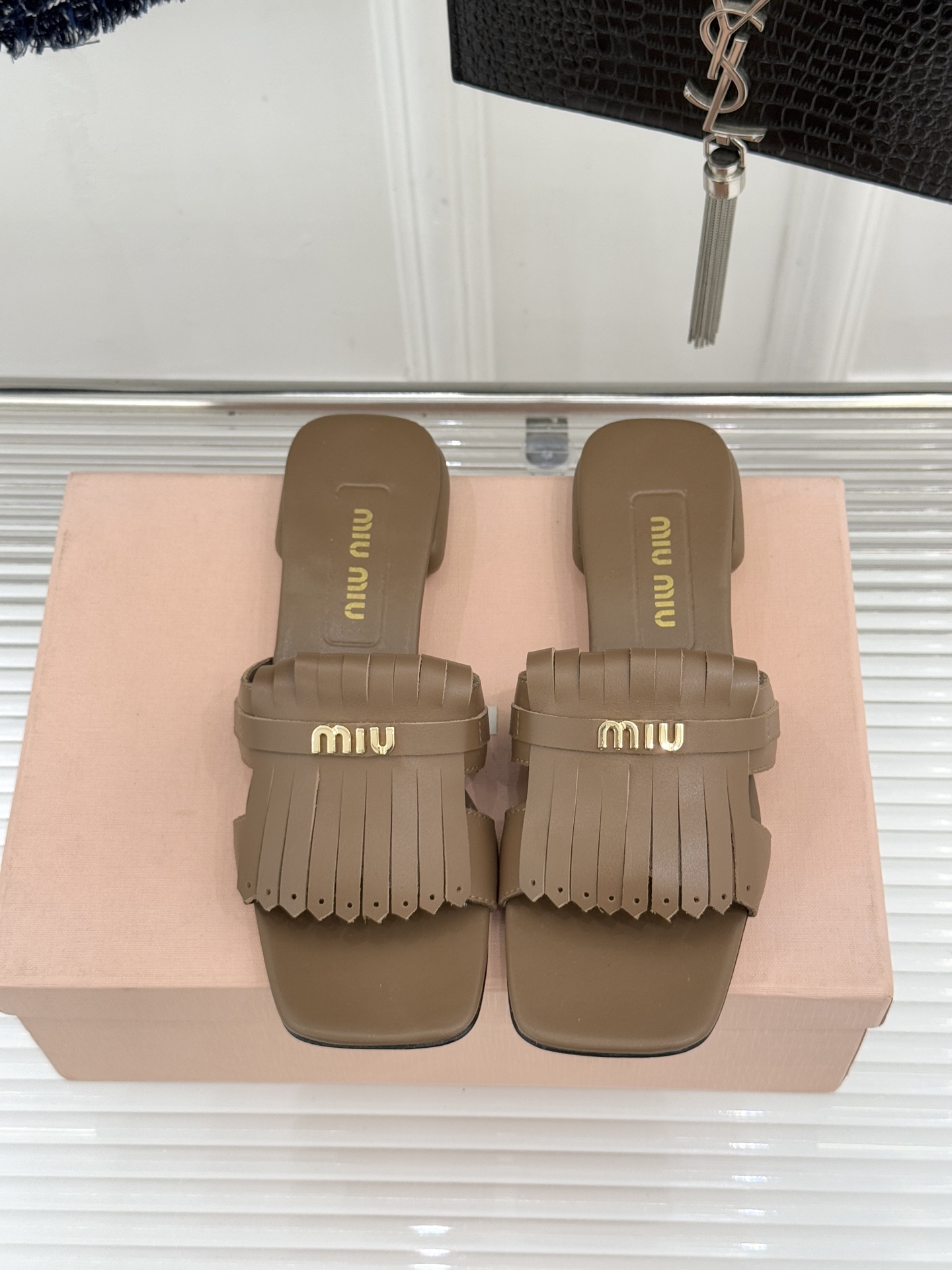 Miu Miu/缪缪26WF早春新品字母流苏猫跟拖鞋将灵动少女感与轻奢格调完美融合。鞋面饰有品牌字母标识