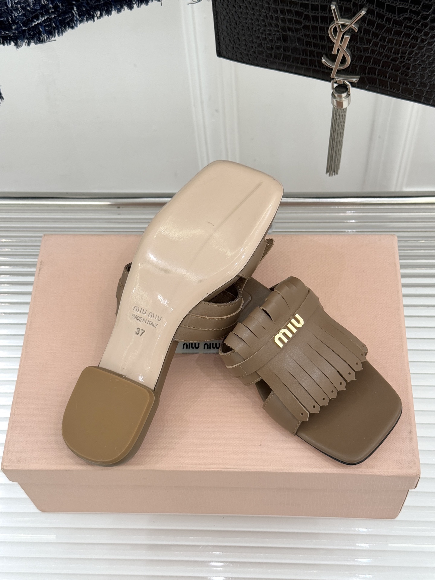 Miu Miu/缪缪26WF早春新品字母流苏猫跟拖鞋将灵动少女感与轻奢格调完美融合。鞋面饰有品牌字母标识