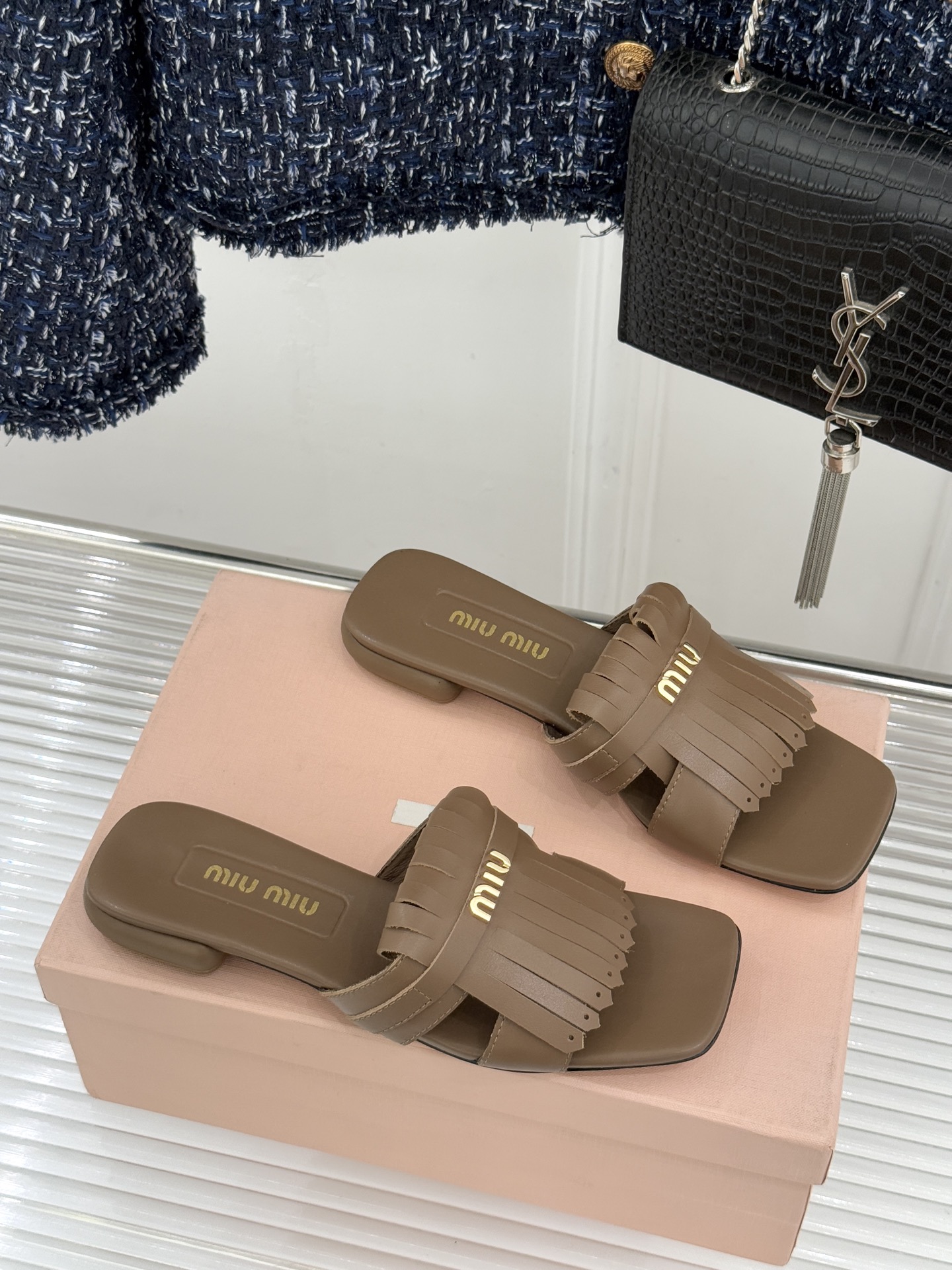 Miu Miu/缪缪26WF早春新品字母流苏猫跟拖鞋将灵动少女感与轻奢格调完美融合。鞋面饰有品牌字母标识