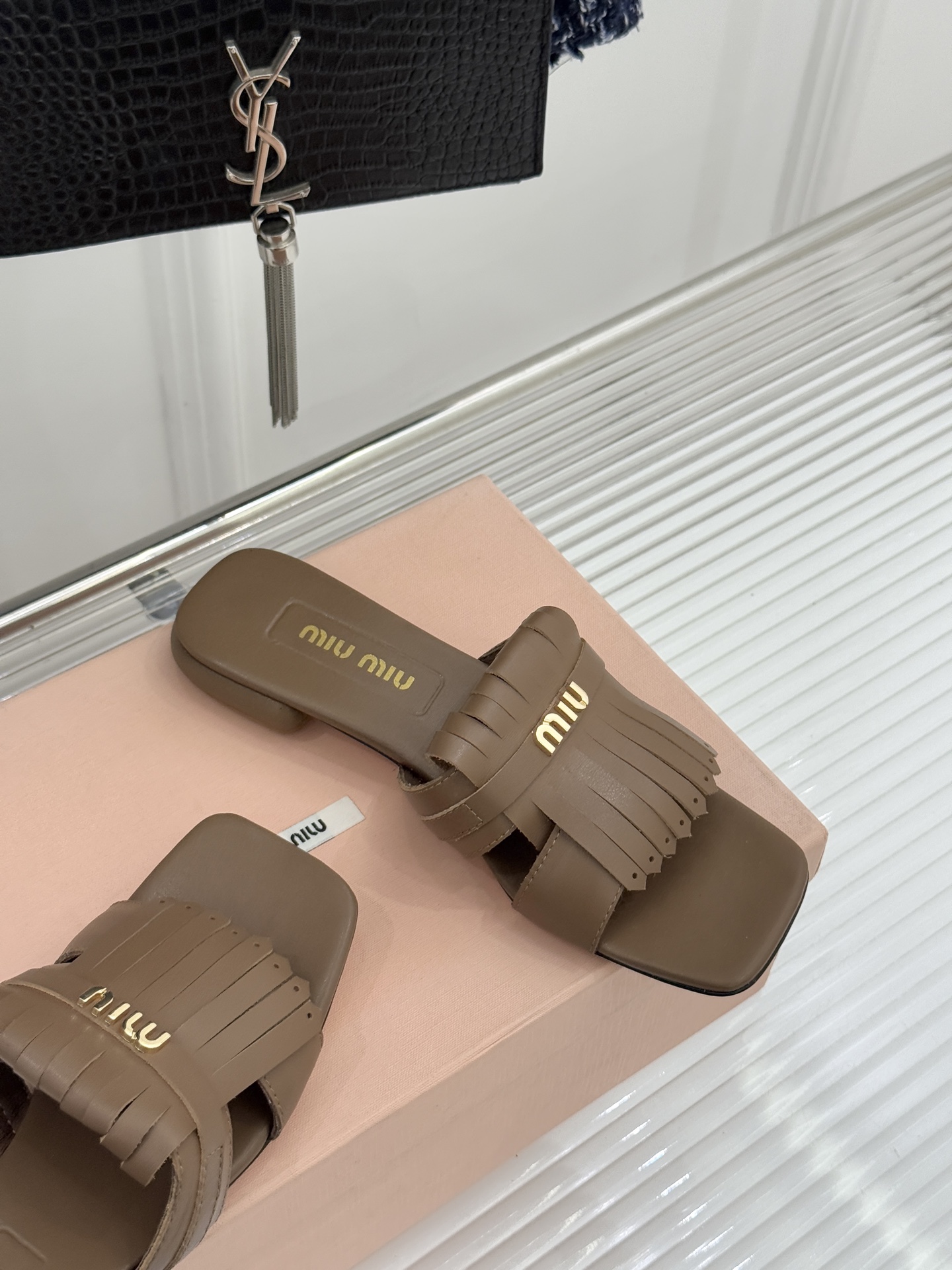 Miu Miu/缪缪26WF早春新品字母流苏猫跟拖鞋将灵动少女感与轻奢格调完美融合。鞋面饰有品牌字母标识