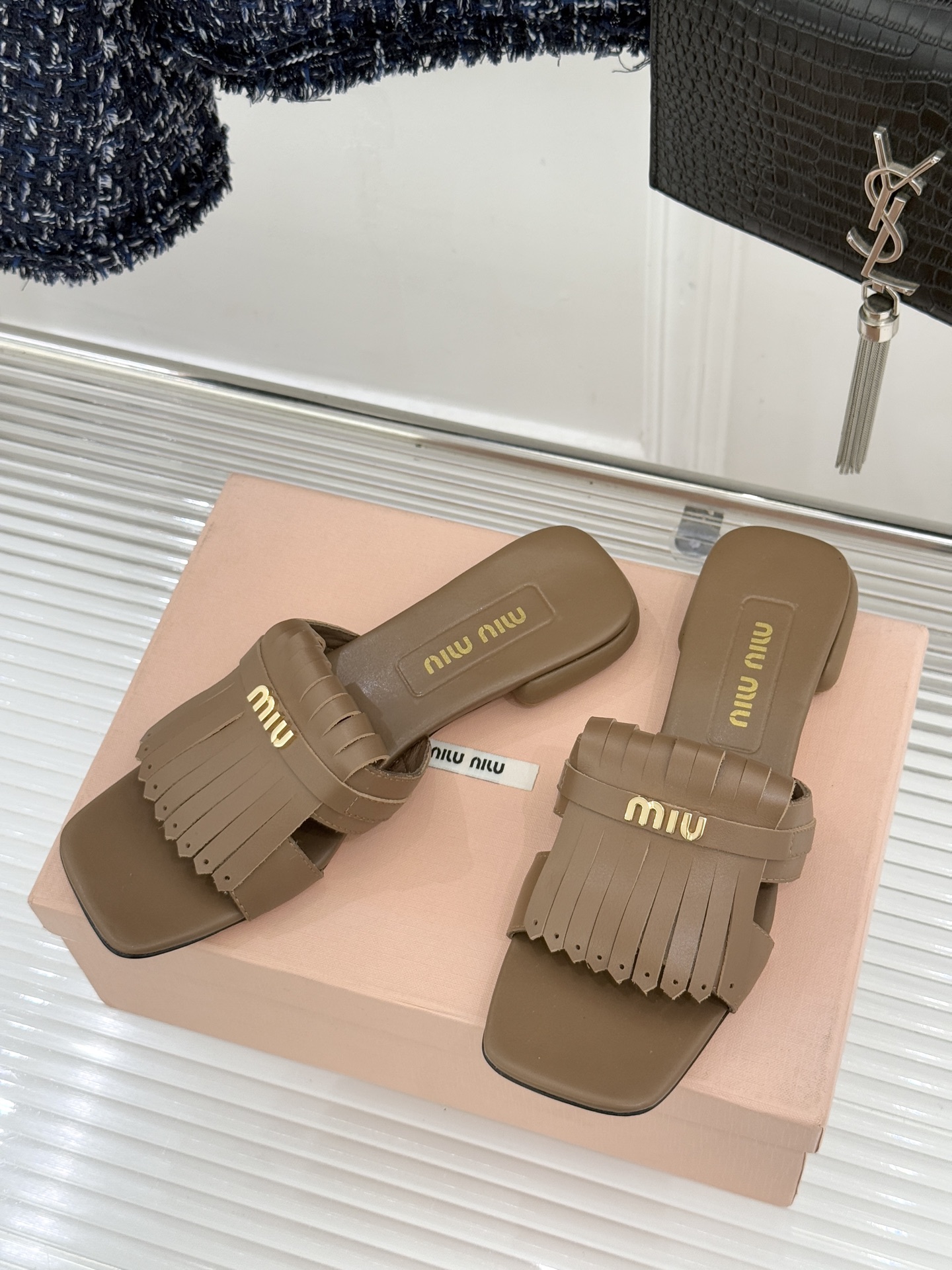 Miu Miu/缪缪26WF早春新品字母流苏猫跟拖鞋将灵动少女感与轻奢格调完美融合。鞋面饰有品牌字母标识