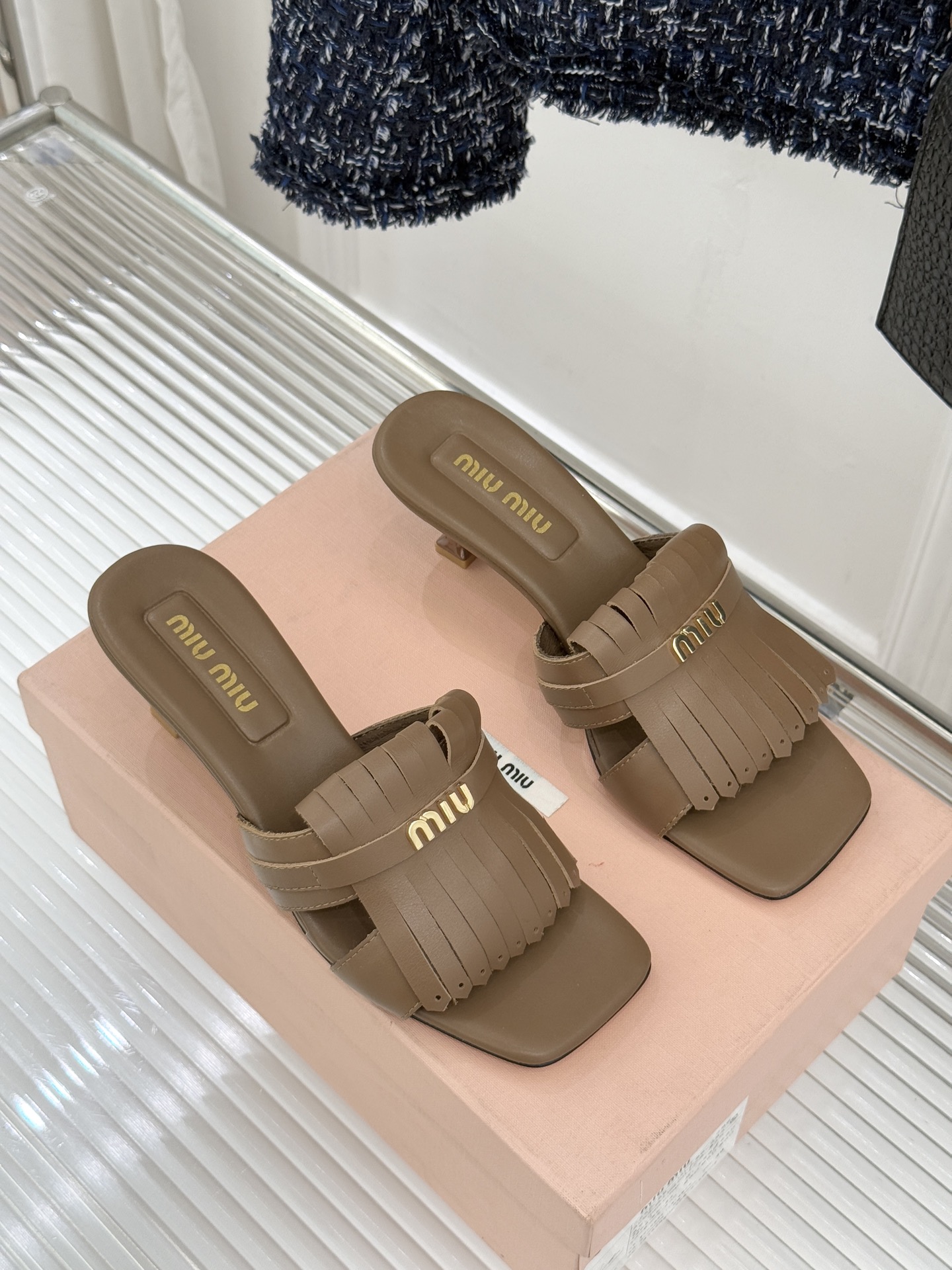 Miu Miu/缪缪26WF早春新品字母流苏猫跟拖鞋将灵动少女感与轻奢格调完美融合。鞋面饰有品牌字母标识