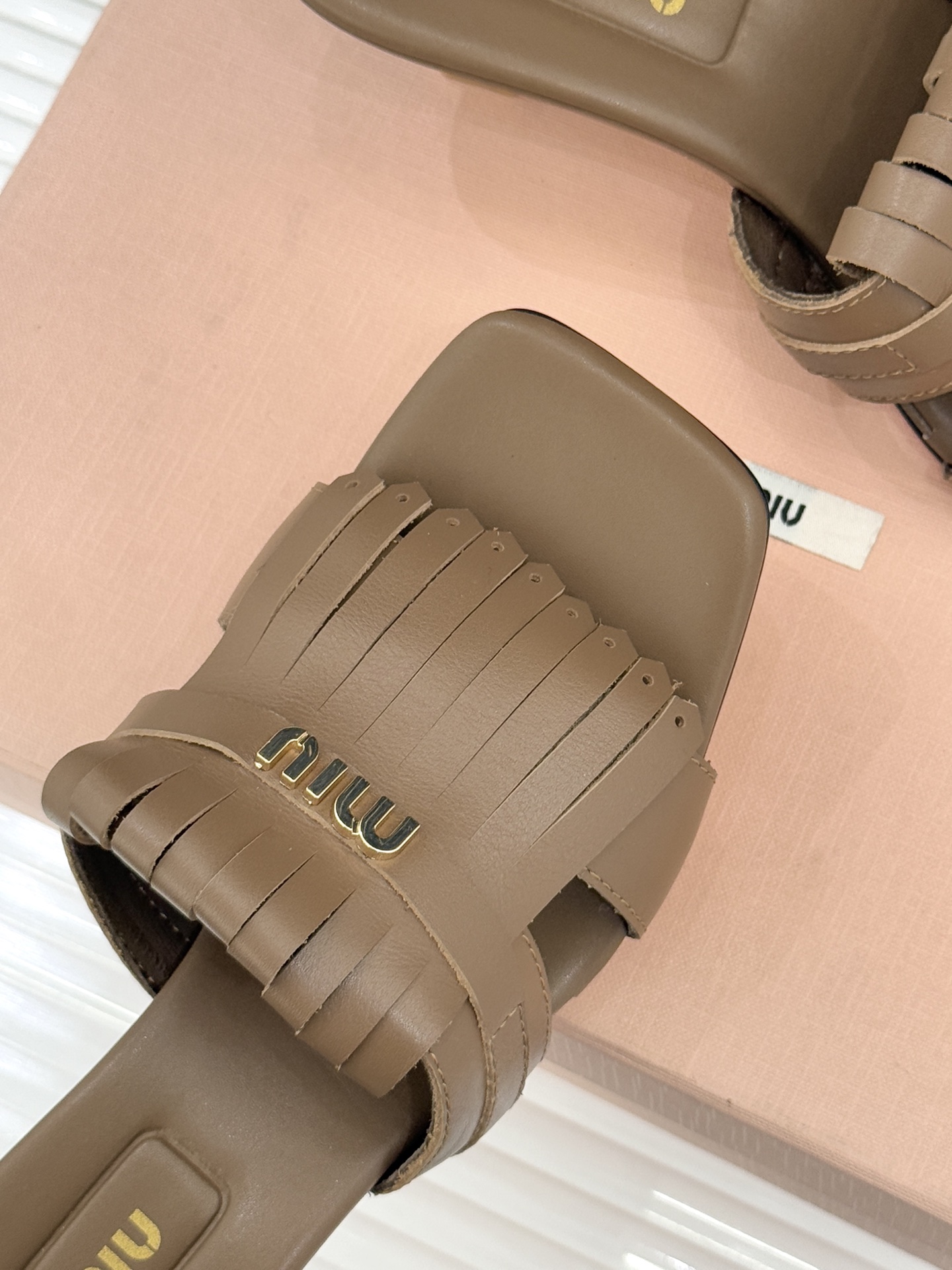 Miu Miu/缪缪26WF早春新品字母流苏猫跟拖鞋将灵动少女感与轻奢格调完美融合。鞋面饰有品牌字母标识