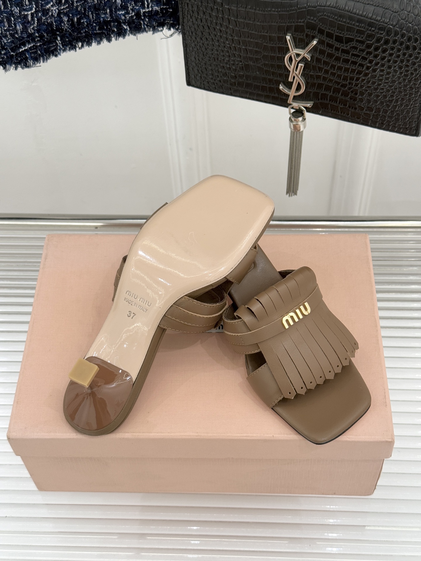 Miu Miu/缪缪26WF早春新品字母流苏猫跟拖鞋将灵动少女感与轻奢格调完美融合。鞋面饰有品牌字母标识