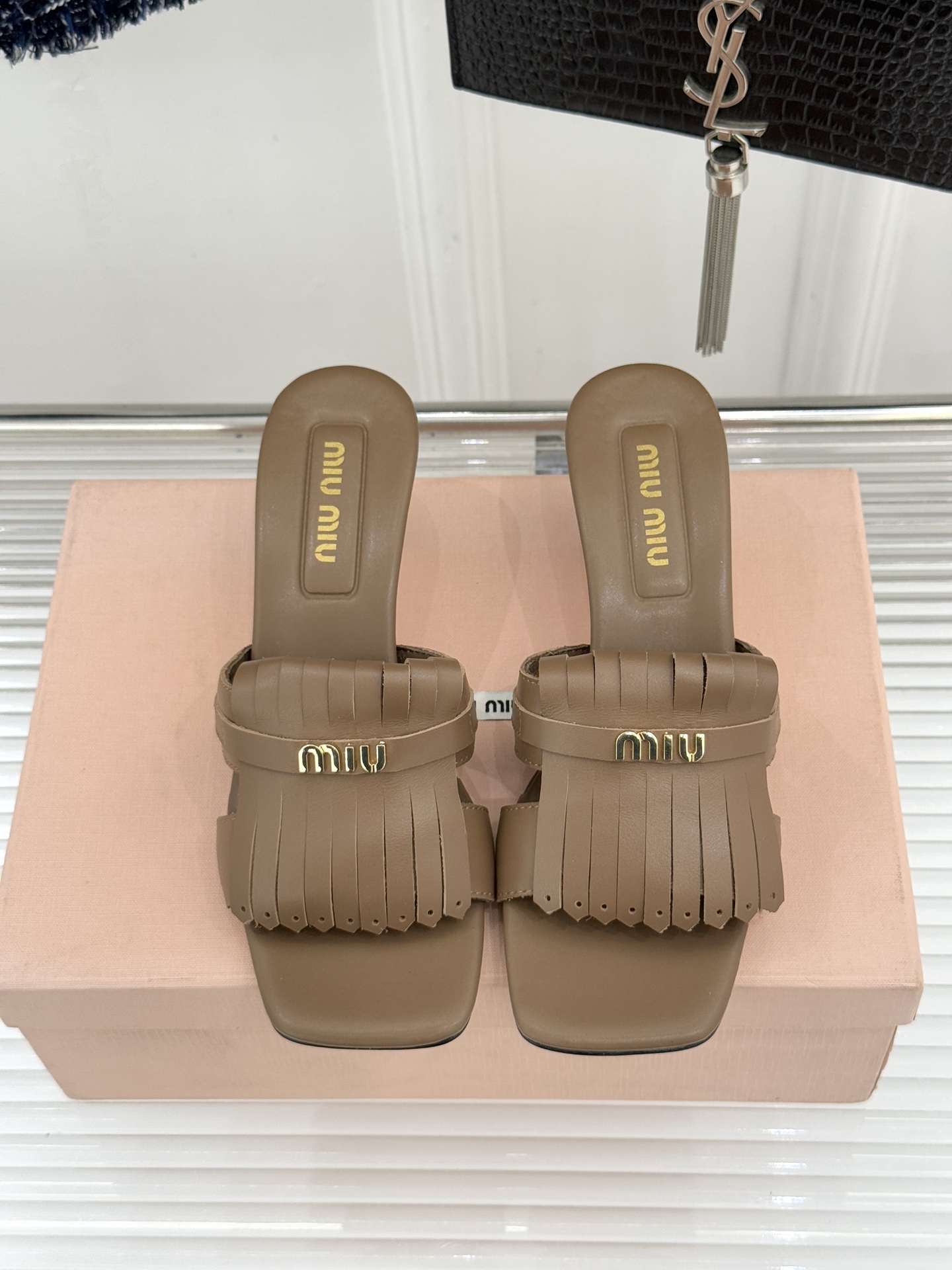 Miu Miu/缪缪26WF早春新品字母流苏猫跟拖鞋将灵动少女感与轻奢格调完美融合。鞋面饰有品牌字母标识