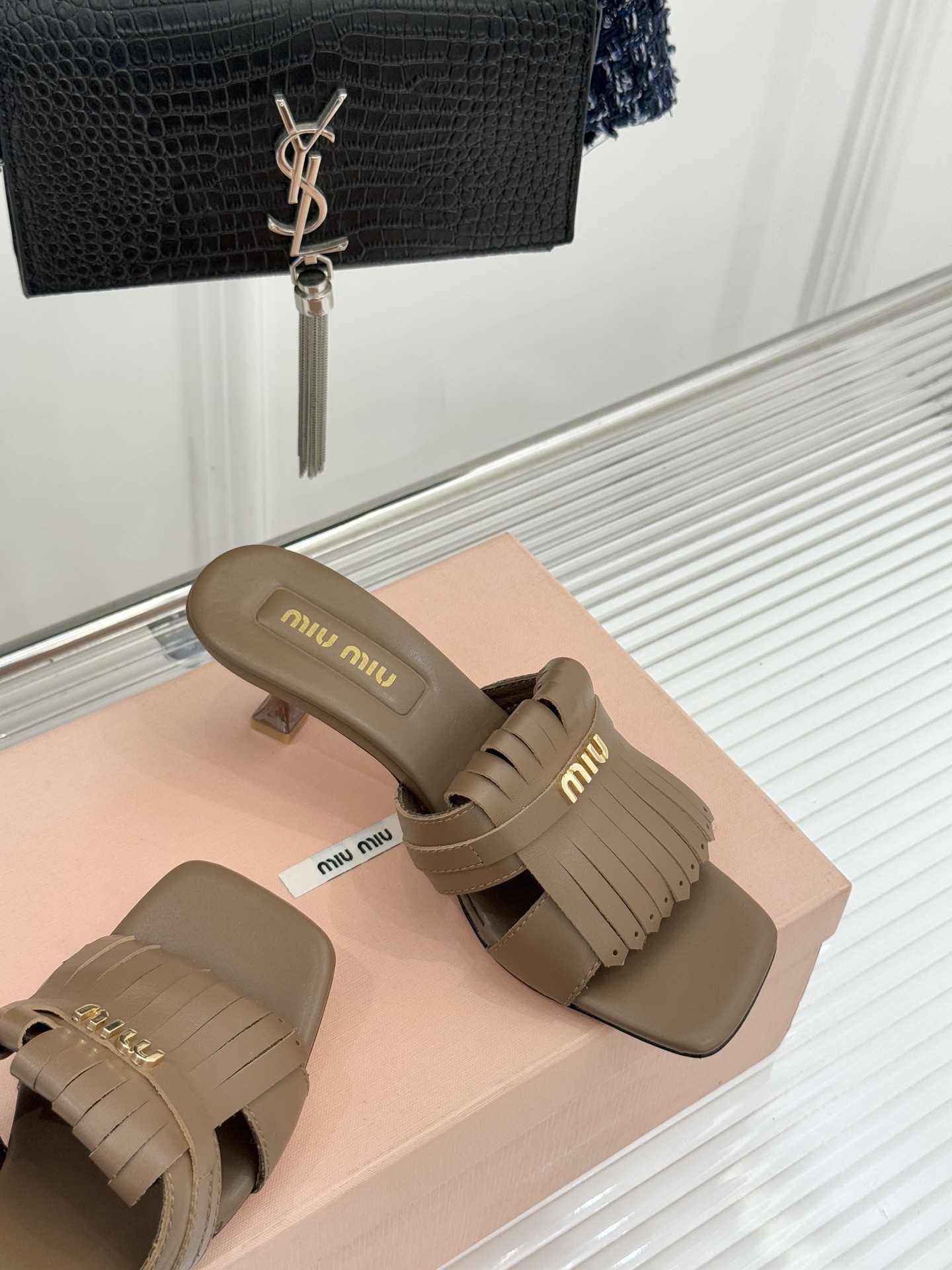 Miu Miu/缪缪26WF早春新品字母流苏猫跟拖鞋将灵动少女感与轻奢格调完美融合。鞋面饰有品牌字母标识