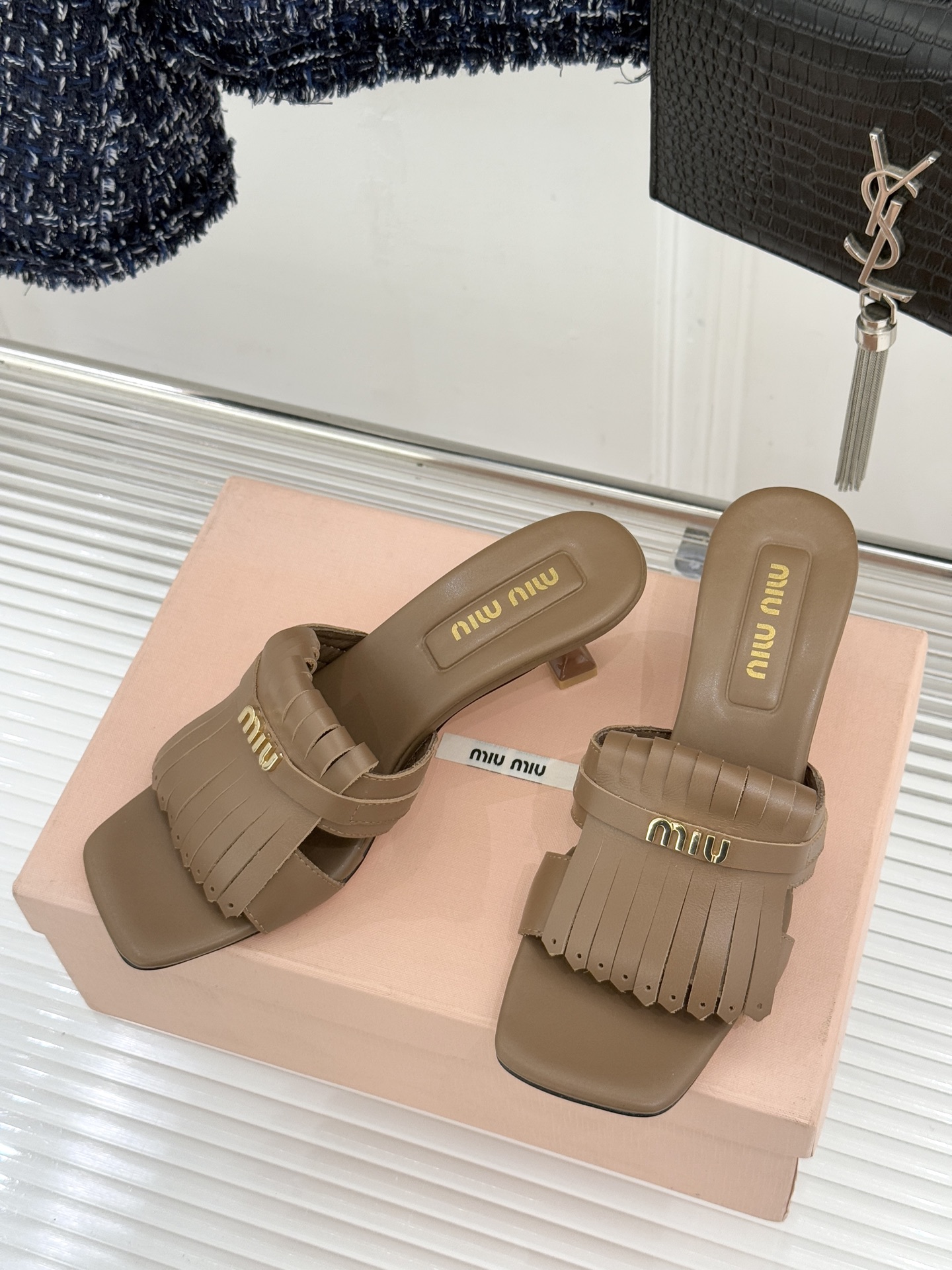 Miu Miu/缪缪26WF早春新品字母流苏猫跟拖鞋将灵动少女感与轻奢格调完美融合。鞋面饰有品牌字母标识