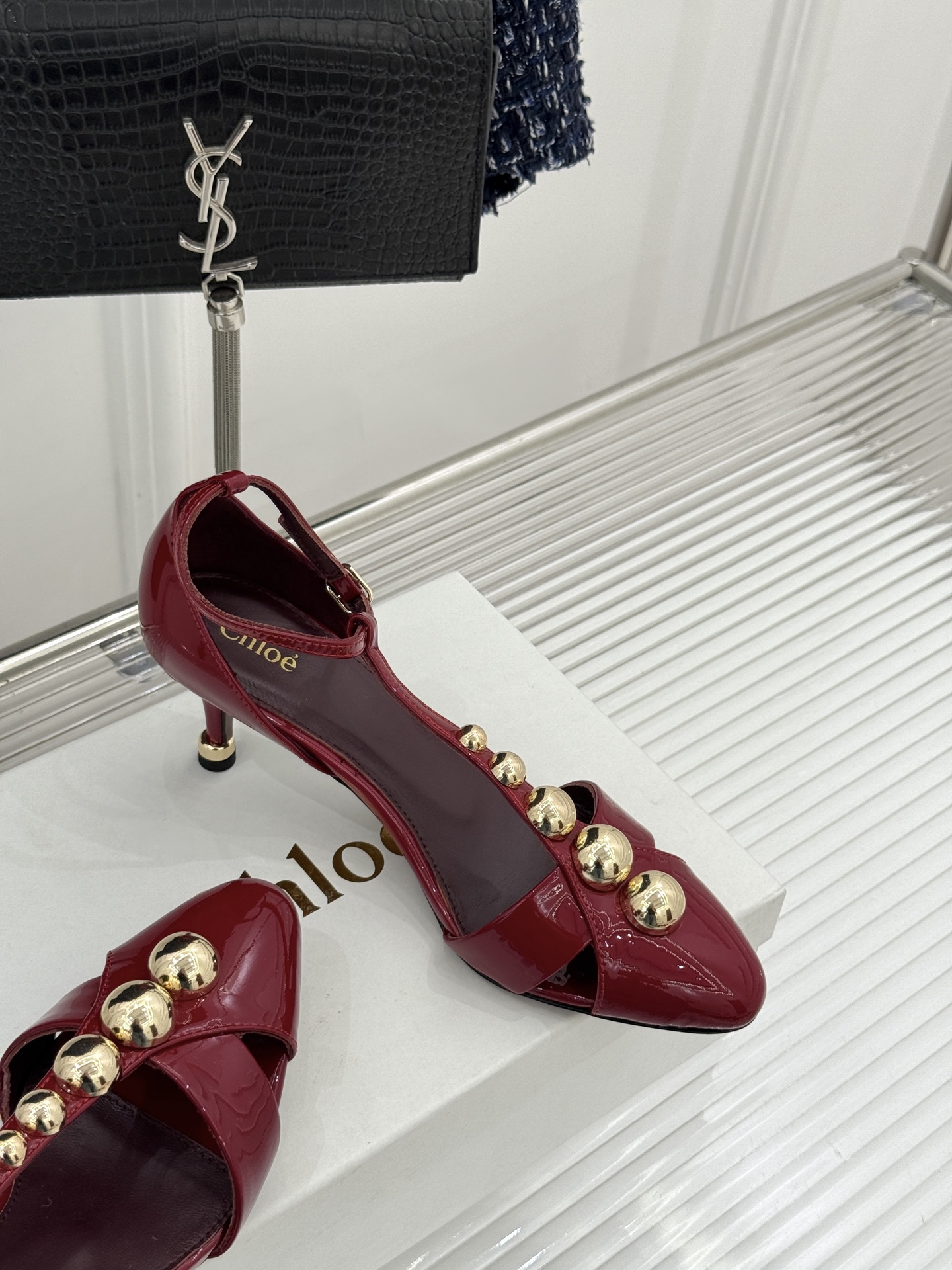 Chloé/蔻依26WF新品Cleia漆皮铆钉镂空T带凉鞋以法式优雅诠释轻奢美学。高光漆皮质感搭配利落尖