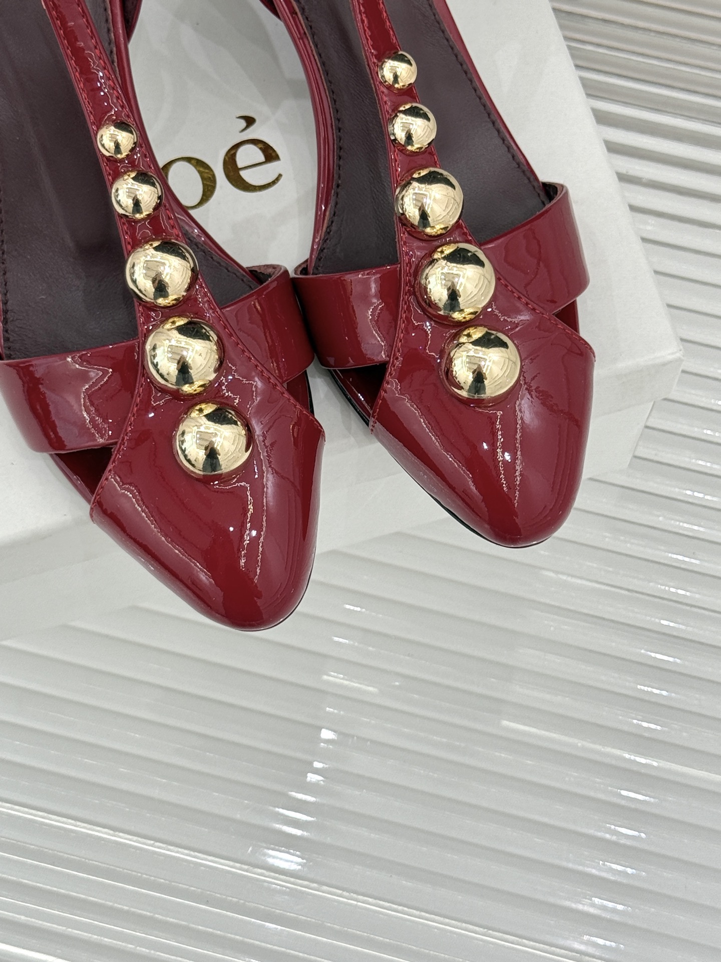 Chloé/蔻依26WF新品Cleia漆皮铆钉镂空T带凉鞋以法式优雅诠释轻奢美学。高光漆皮质感搭配利落尖