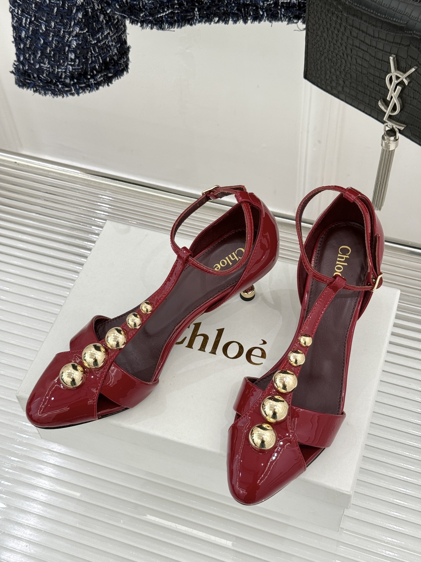 Chloé/蔻依26WF新品Cleia漆皮铆钉镂空T带凉鞋以法式优雅诠释轻奢美学。高光漆皮质感搭配利落尖