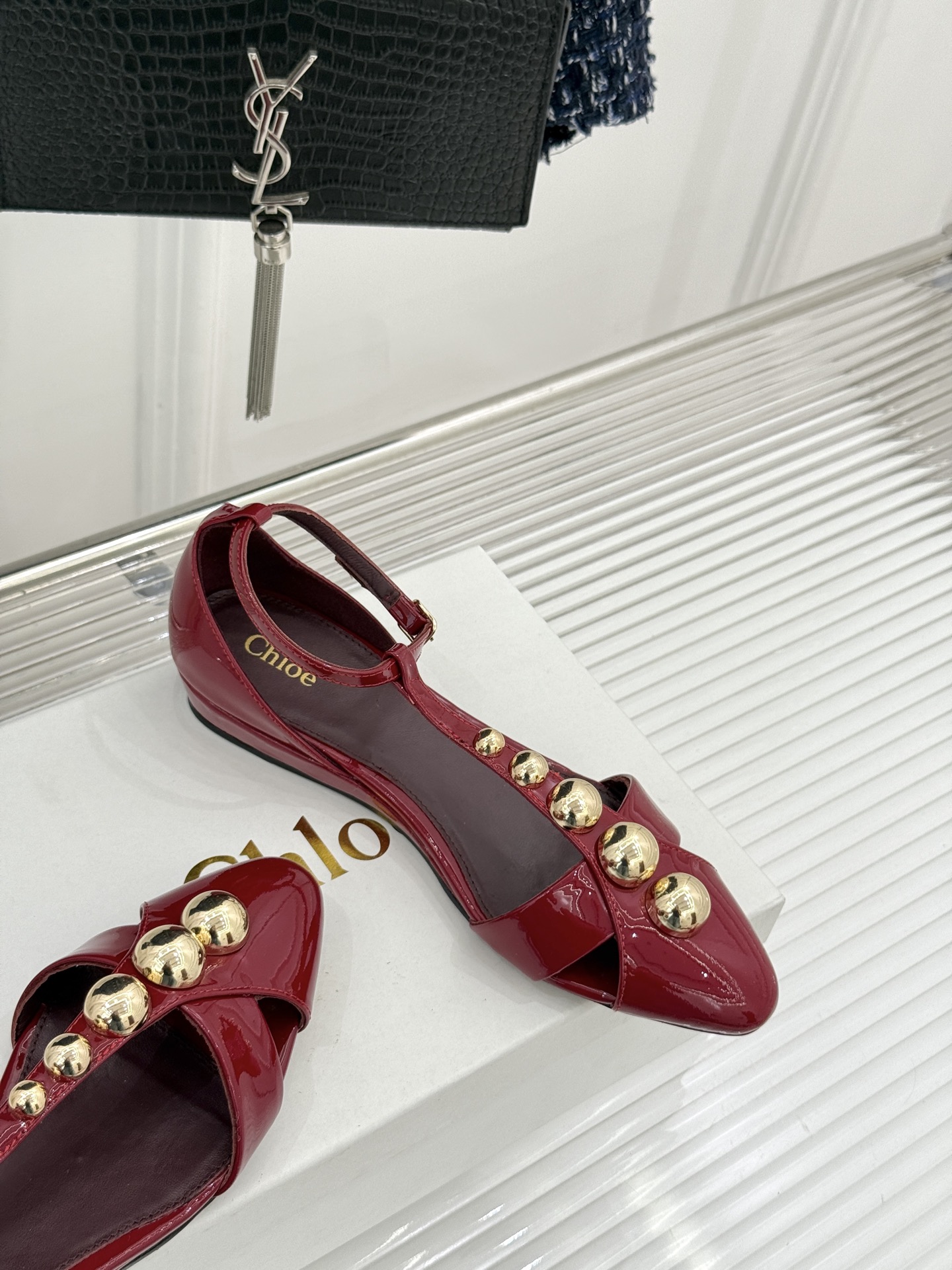 Chloé/蔻依26WF新品Cleia漆皮铆钉镂空T带凉鞋以法式优雅诠释轻奢美学。高光漆皮质感搭配利落尖