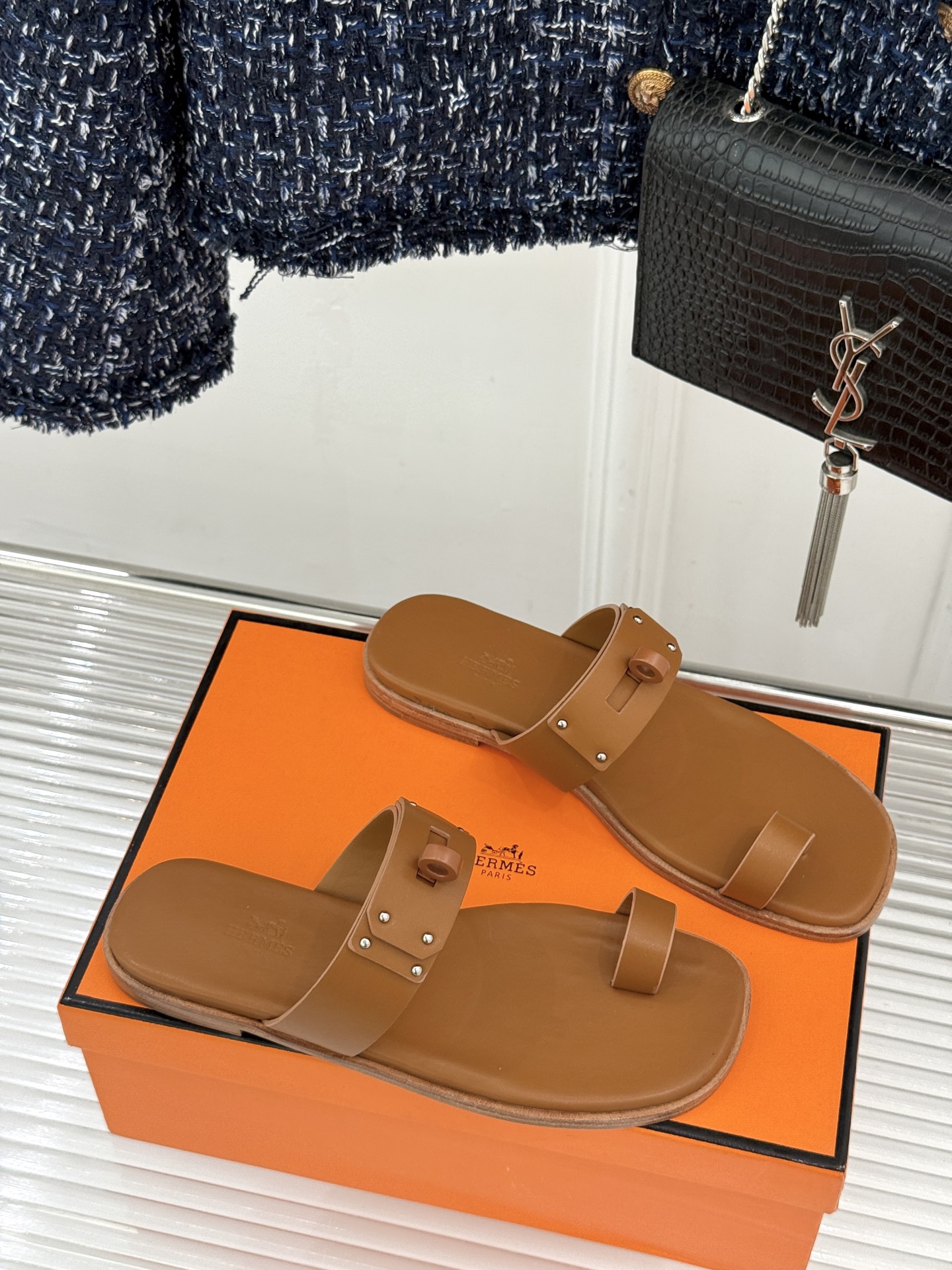 Hermès/爱马仕经典Kelly夹脚拖鞋以经典Kelly金属扣重塑夹脚拖鞋格调。甄选细腻小牛皮 触感柔