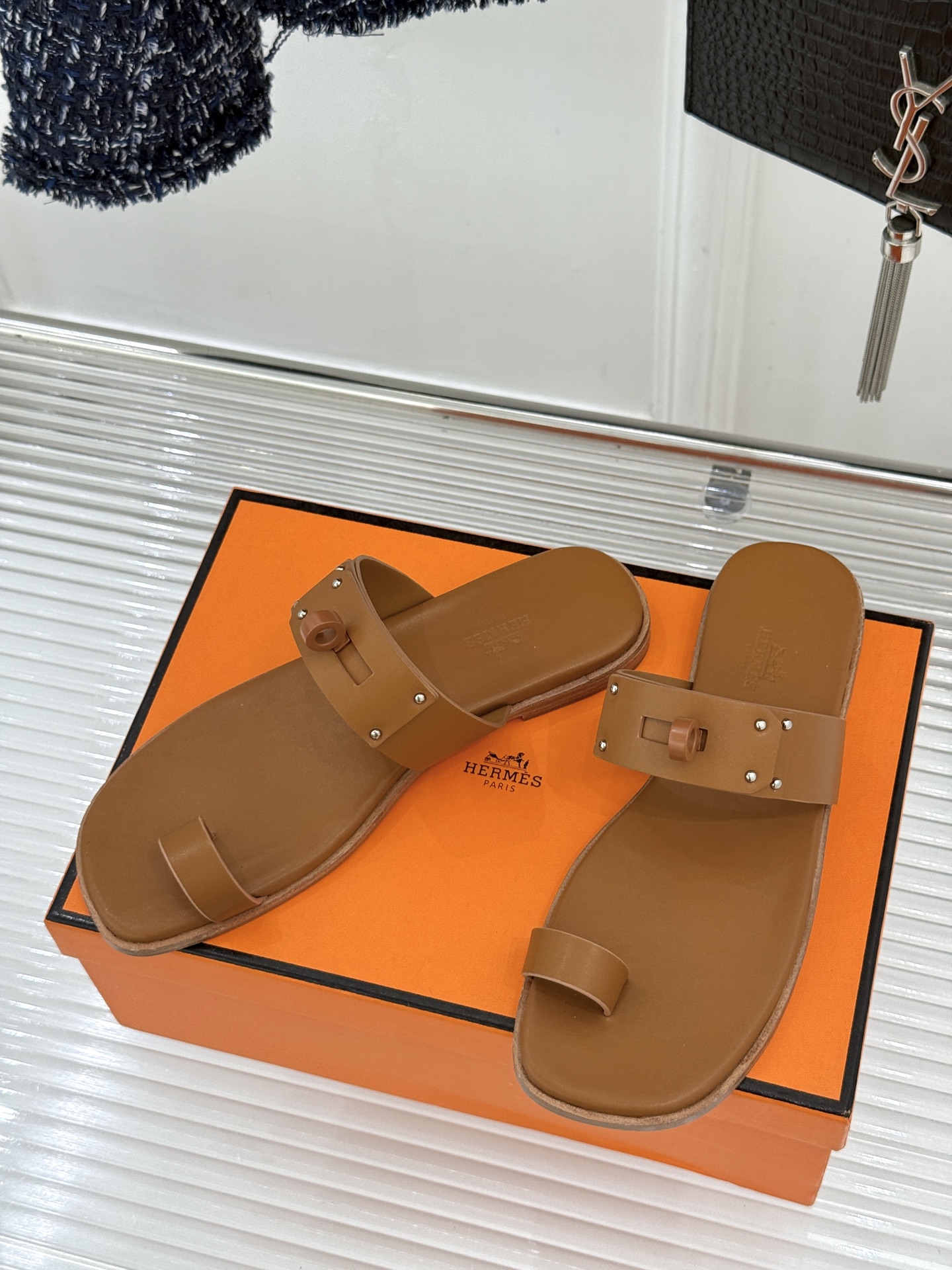 Hermès/爱马仕经典Kelly夹脚拖鞋以经典Kelly金属扣重塑夹脚拖鞋格调。甄选细腻小牛皮 触感柔