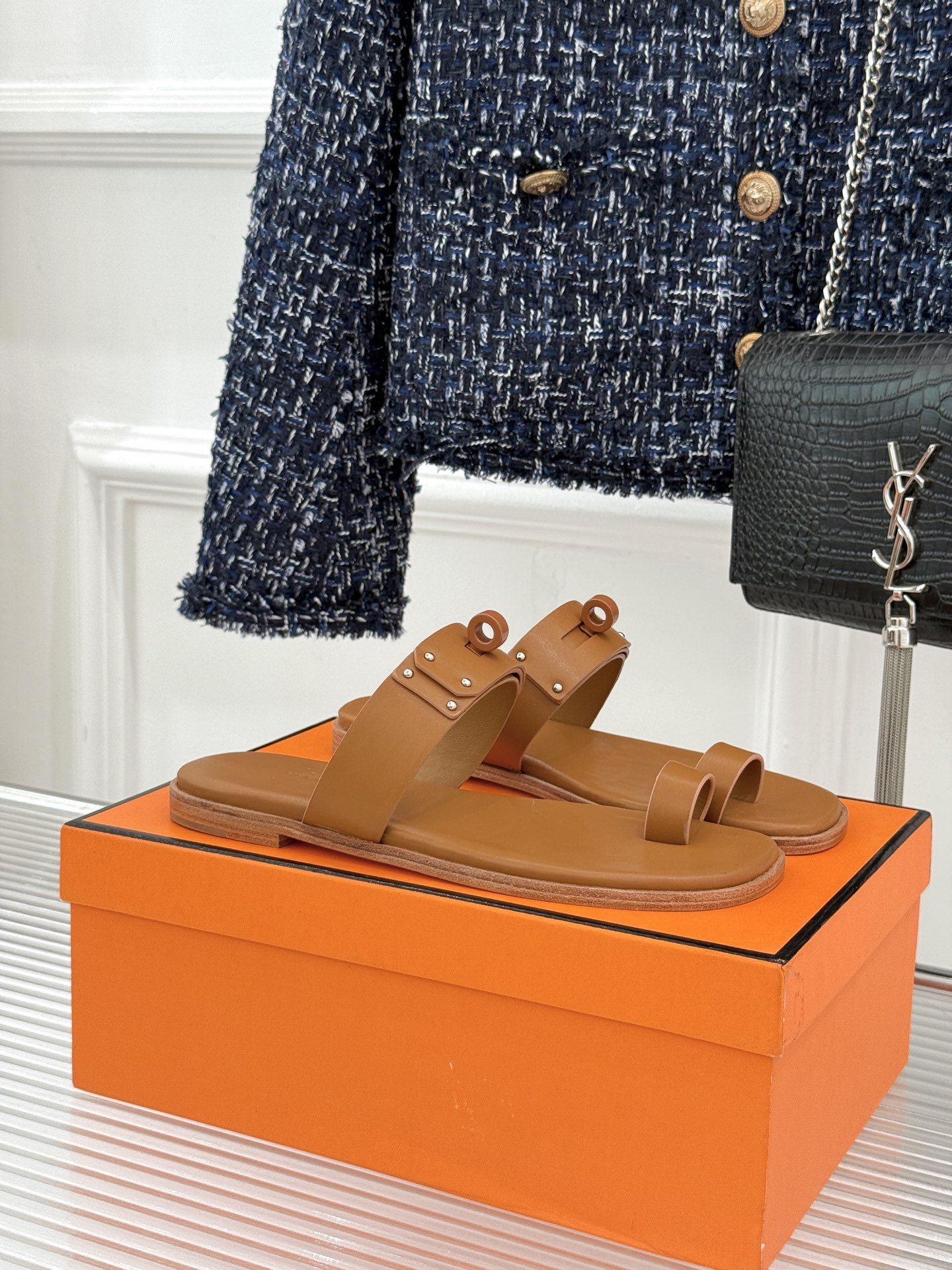 Hermès/爱马仕经典Kelly夹脚拖鞋以经典Kelly金属扣重塑夹脚拖鞋格调。甄选细腻小牛皮 触感柔