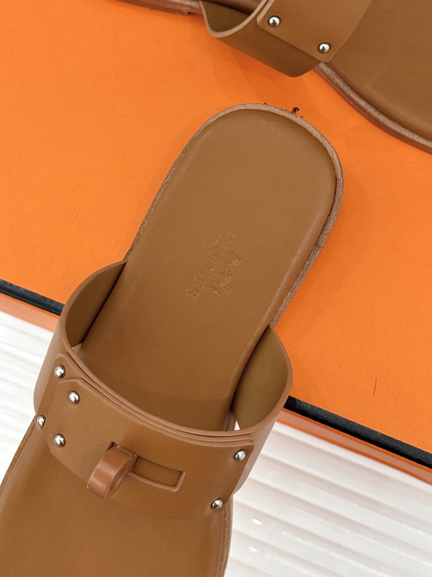 Hermès/爱马仕经典Kelly夹脚拖鞋以经典Kelly金属扣重塑夹脚拖鞋格调。甄选细腻小牛皮 触感柔