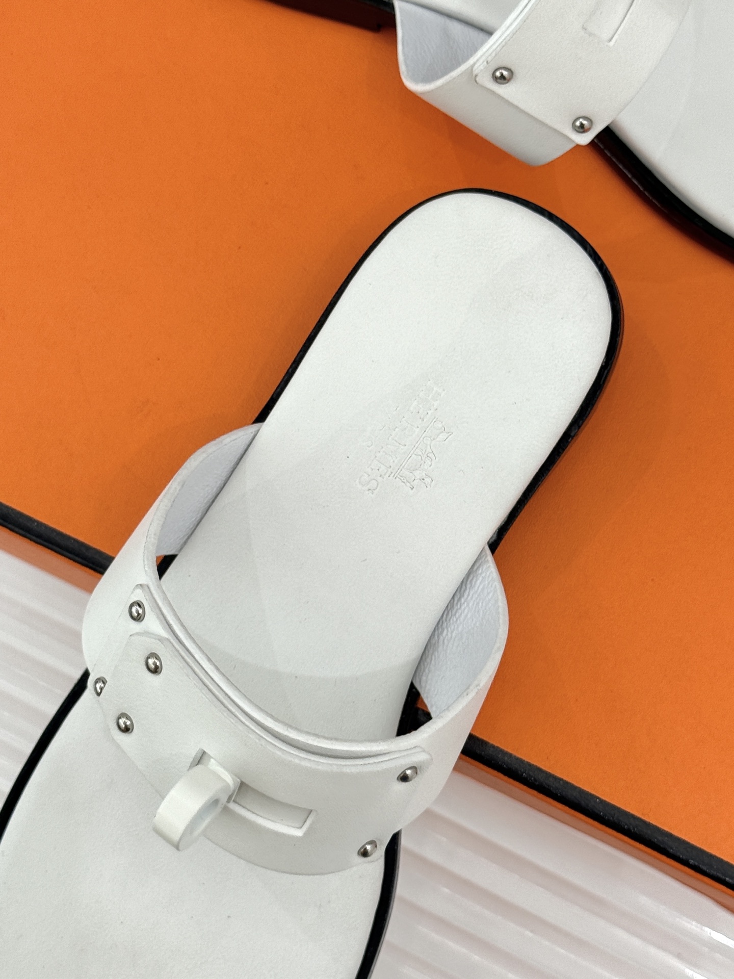 Hermès/爱马仕经典Kelly夹脚拖鞋以经典Kelly金属扣重塑夹脚拖鞋格调。甄选细腻小牛皮 触感柔