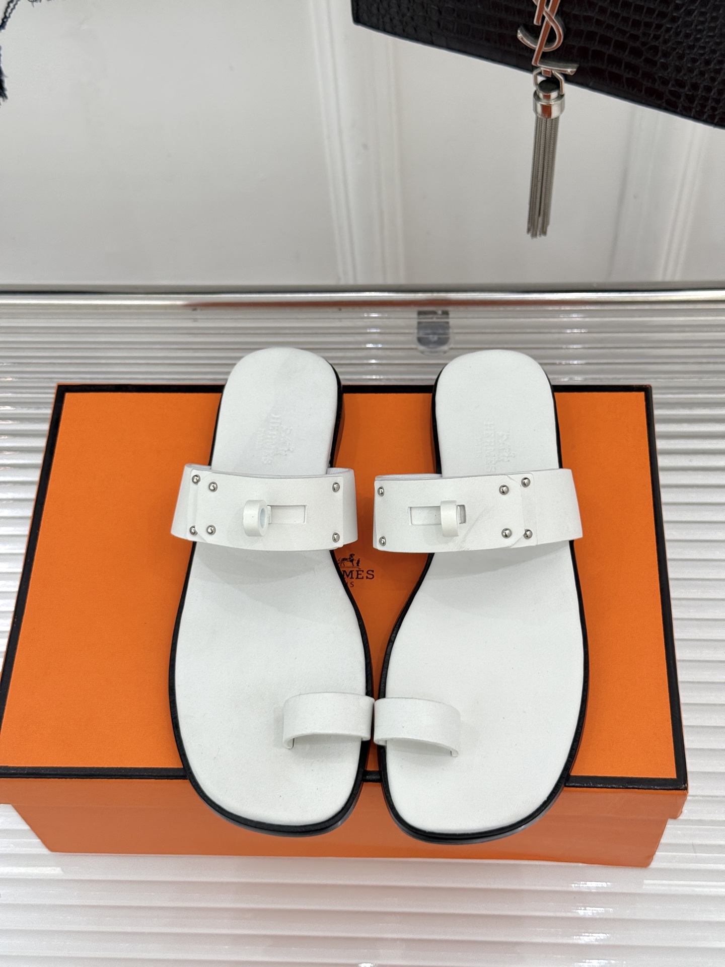 Hermès/爱马仕经典Kelly夹脚拖鞋以经典Kelly金属扣重塑夹脚拖鞋格调。甄选细腻小牛皮 触感柔