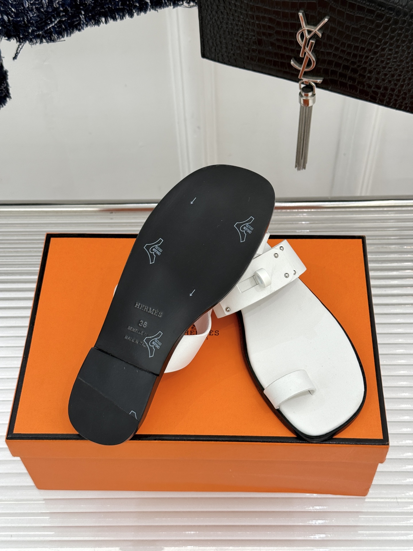 Hermès/爱马仕经典Kelly夹脚拖鞋以经典Kelly金属扣重塑夹脚拖鞋格调。甄选细腻小牛皮 触感柔