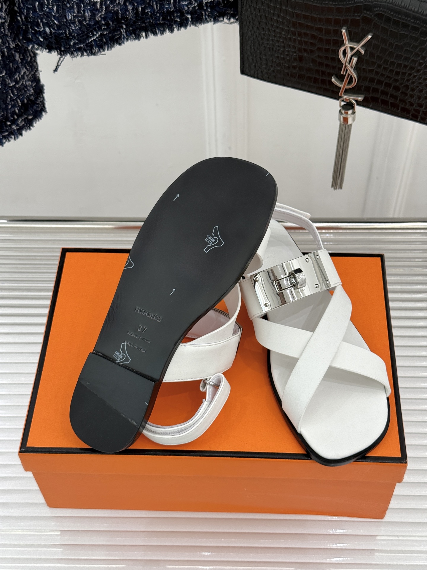 Hermès/爱马仕经典Kelly交叉带凉鞋以标志性大Kelly扣演绎优雅新境。精选细腻小牛皮 质感温润