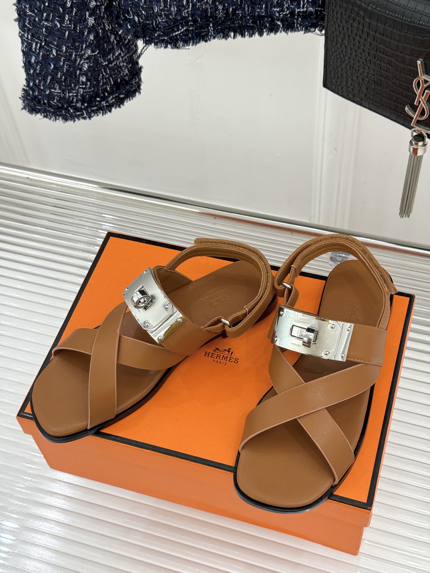 Hermès/爱马仕经典Kelly交叉带凉鞋以标志性大Kelly扣演绎优雅新境。精选细腻小牛皮 质感温润