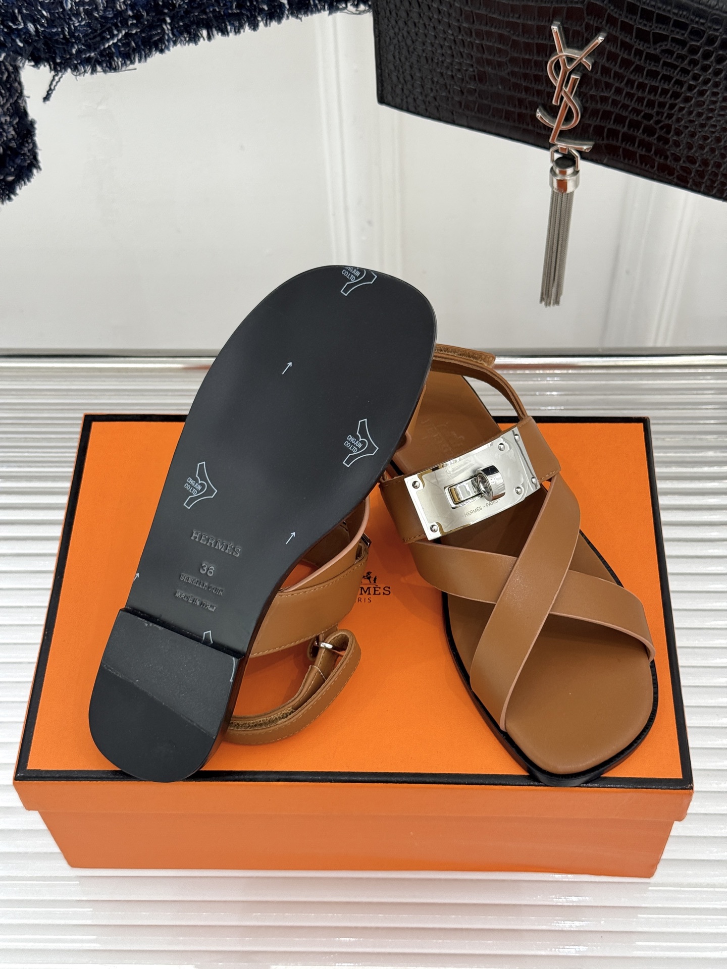 Hermès/爱马仕经典Kelly交叉带凉鞋以标志性大Kelly扣演绎优雅新境。精选细腻小牛皮 质感温润