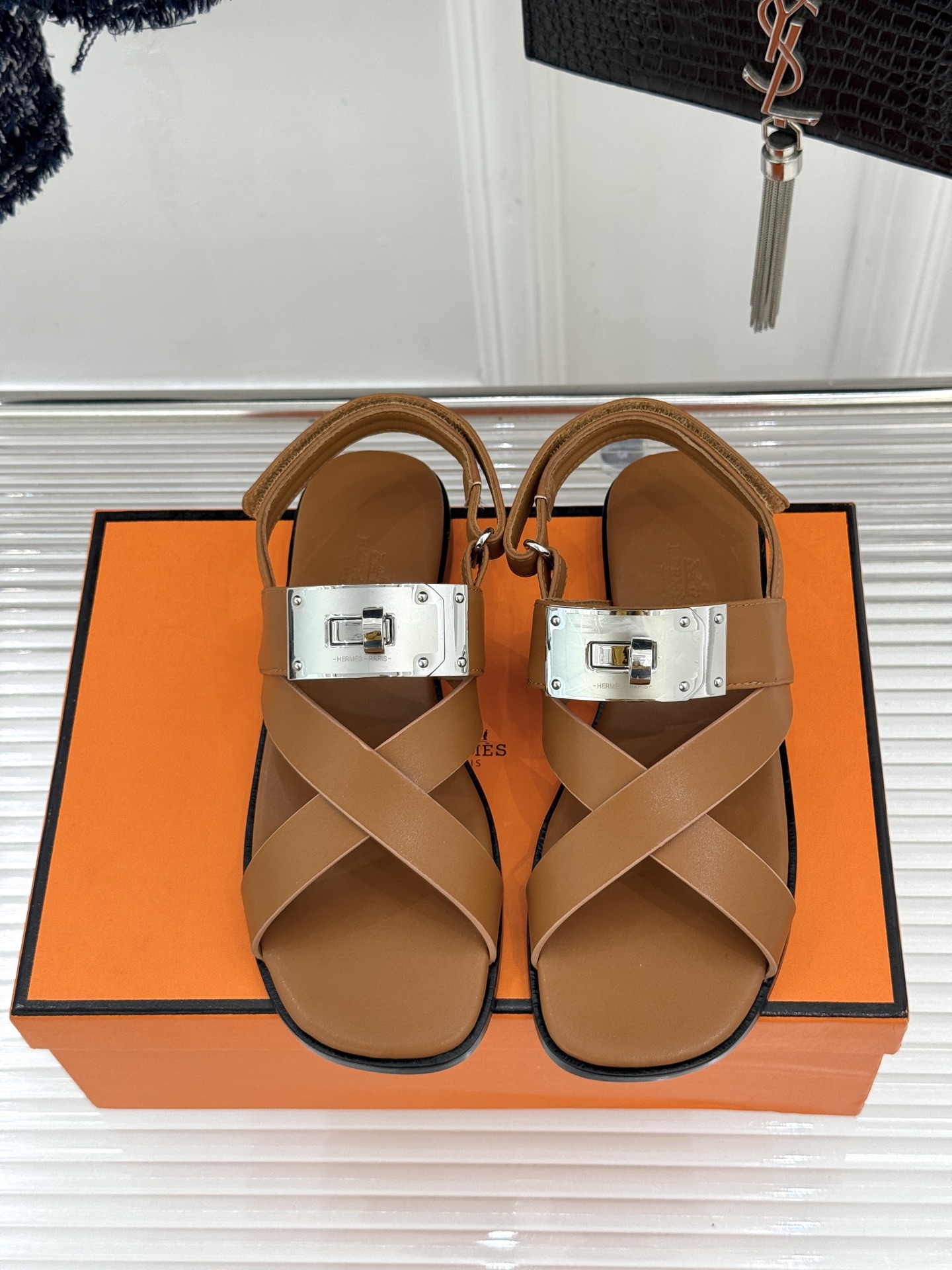 Hermès/爱马仕经典Kelly交叉带凉鞋以标志性大Kelly扣演绎优雅新境。精选细腻小牛皮 质感温润