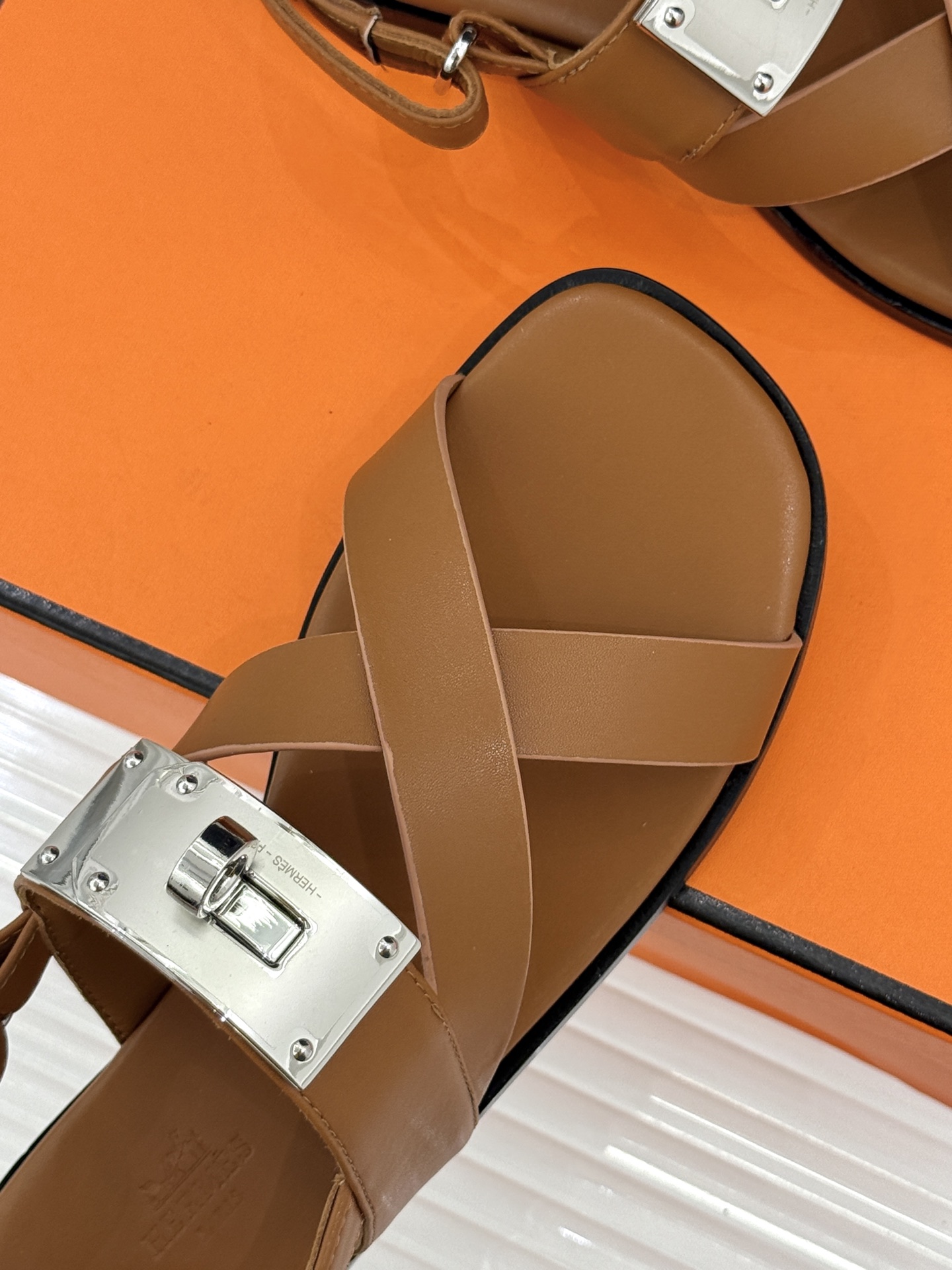 Hermès/爱马仕经典Kelly交叉带凉鞋以标志性大Kelly扣演绎优雅新境。精选细腻小牛皮 质感温润