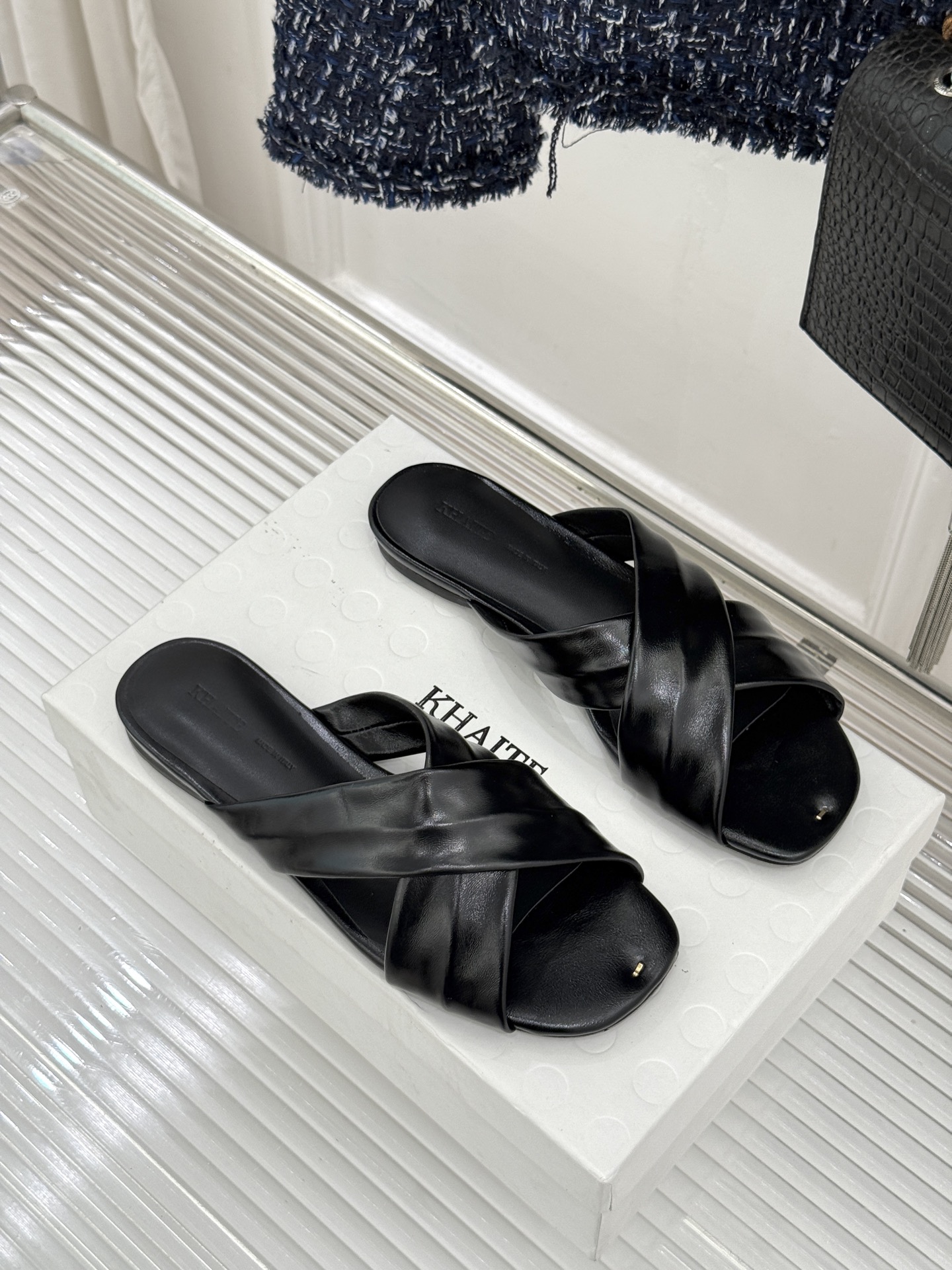 Khaite 26WF新品极简交叉带平底粗跟拖鞋以“情绪极简”重塑慵懒格调。利落交叉带简约利落 无多余装