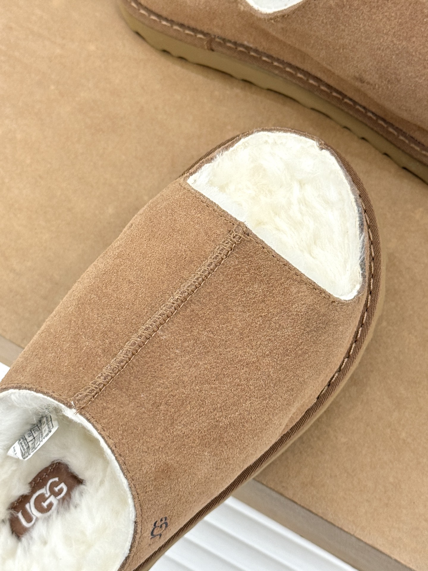 UGG 26WF新品复古 厚底松糕一字带毛拖 厚底松糕悄悄拔高身形 一字带藏着复古腔调 羊羔毛裹住冬日满格暖意 皮毛一体