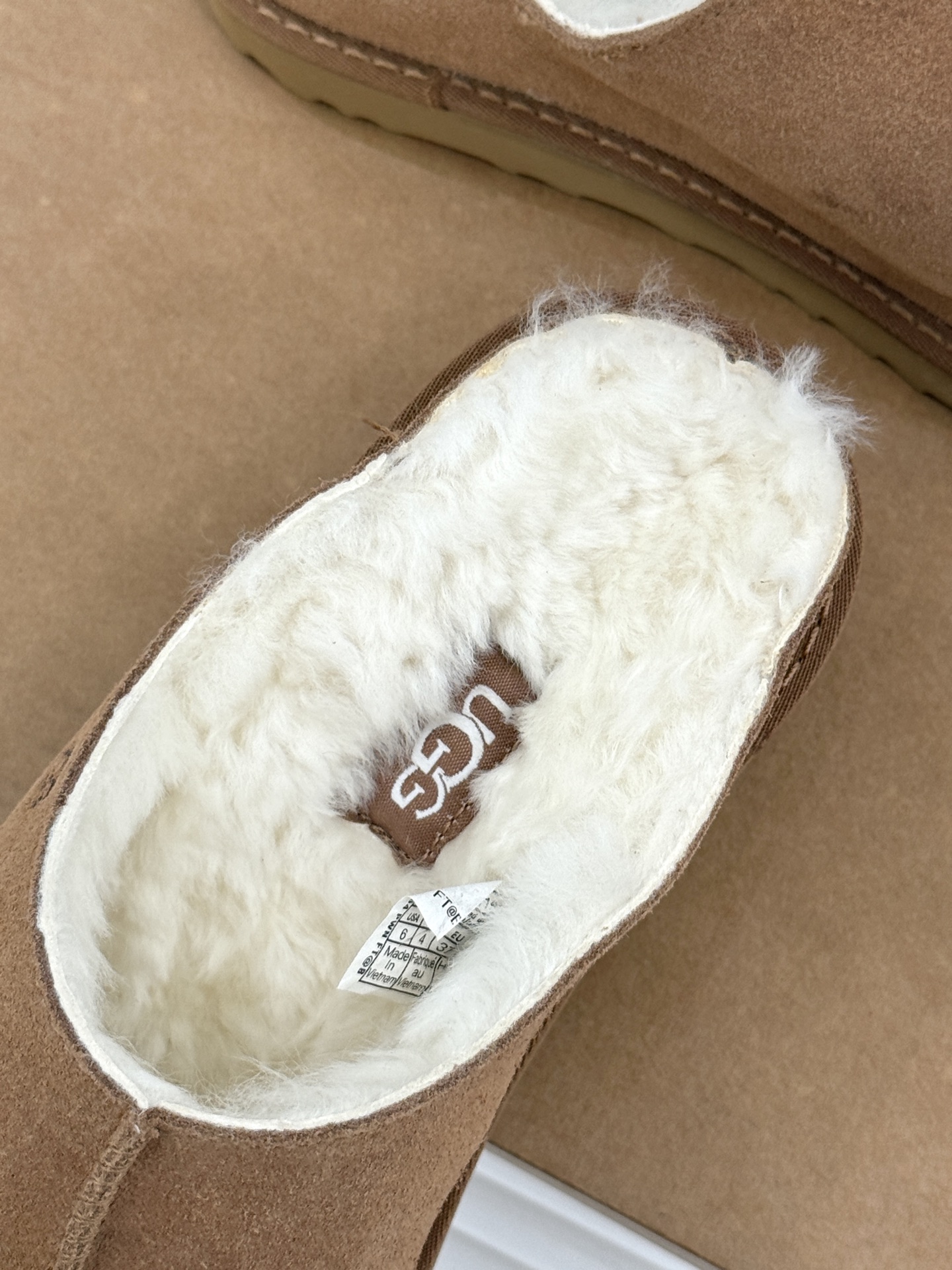 UGG 26WF新品复古 厚底松糕一字带毛拖 厚底松糕悄悄拔高身形 一字带藏着复古腔调 羊羔毛裹住冬日满格暖意 皮毛一体