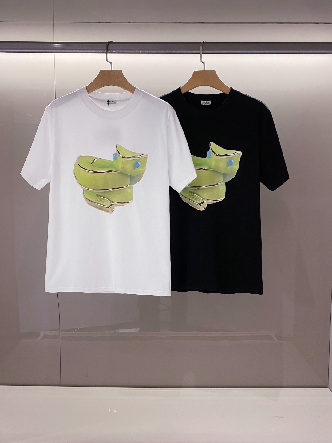 NO:136370,[New Product] 2025 Spring and Summer New Lo*we Lingser Graphic Print Cotton Short-sleeved T-shirt for Men and Women. The simplified charm lies in creating a luxurious silhouette and fashion, and the unique temperament of the trendy style is casually matched. Lightweight technology knitted cotton fabric, texture and feel are all complete masterpieces, comfortable and breathable, and the cutting style is a witness to the classic charm. The new Lingser graphic printing logo design does not need to be explained deliberately. The three-dimensional feeling is strong, neat and symmetrical difference between traditional offset printing patterns. Color black and white Size S M L XL XXL XXL Size data S shoulder width 46cm-bust 104cm-length 66cm M shoulder width 49cm-bust 110cm-length 68cm  L size shoulder width 52cm-bust 116cm-cloth 70cm XL size shoulder width 55cm-bust 121cm-cloth 72cm XXL size shoulder width 57cm-bust 126cm-cloth 74cm, T-shirt,tees,t-shirt,alexander wang19860909【新品】2025春夏新品Lo*we 灵蛇图形印花男女同款棉质短袖T恤.精简魅力在于创造了奢华感的廓形时尚,随意搭配感受潮流风格独特气质.轻盈科技针织棉面料,质地手感都是完完全全的精品力作,舒爽透气,裁剪版型的功底见证了经典魅力所在.焕然一新的灵蛇造型图形印花标识设计无需刻意去解释.立体感强,工整对称区别传统胶印图案. 颜色黑色 白色 尺码S M L XL XXL XXL 尺码数据 S码肩宽46cm-胸围104cm-衣长66cm M码肩宽49cm-胸围110cm-衣长68cm L码肩宽52cm-胸围116cm-衣长70cm XL码肩宽55cm-胸围121cm-衣长72cm XXL码肩宽57cm-胸围126cm-衣长74cm,,T-shirt,tees，t-shirt,alexander wang,Men's clothing