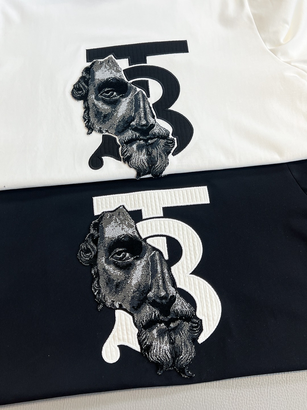 P120🍀【新品】香港洋行渠道货.2025夏季新品Bur*erry 全是残缺肖像植绒标识短袖T恤 .精简魅力在于创造了奢华感的时尚,随意搭配感受英式风格独特气质.针织棉面料,质地手感都是完完全全的精品力作,舒爽透气,裁剪版型的功底见证英式经典的魅力所在.焕然一新的典藏级别TB标签无需刻意去解释.全新刺绣+立体植绒工艺制作,色泽及立体感彰显无以比拟的精细度及优越性....
颜色：黑色 白色 
尺码：S M L XL XXL
尺码数据：
S码:胸围102cm-肩宽45cm-衣长69cm-袖长22cm
M码:胸围106cm-肩宽46cm-衣长70cm-袖长23cm
L码:胸围110cm-肩宽47cm-衣长71cm-袖长24cm
XL码:胸围114cm-肩宽48cm-衣长72cm-袖长25cm
XXL码:胸围118cm-肩宽49cm-衣长73cm-袖长26cm
