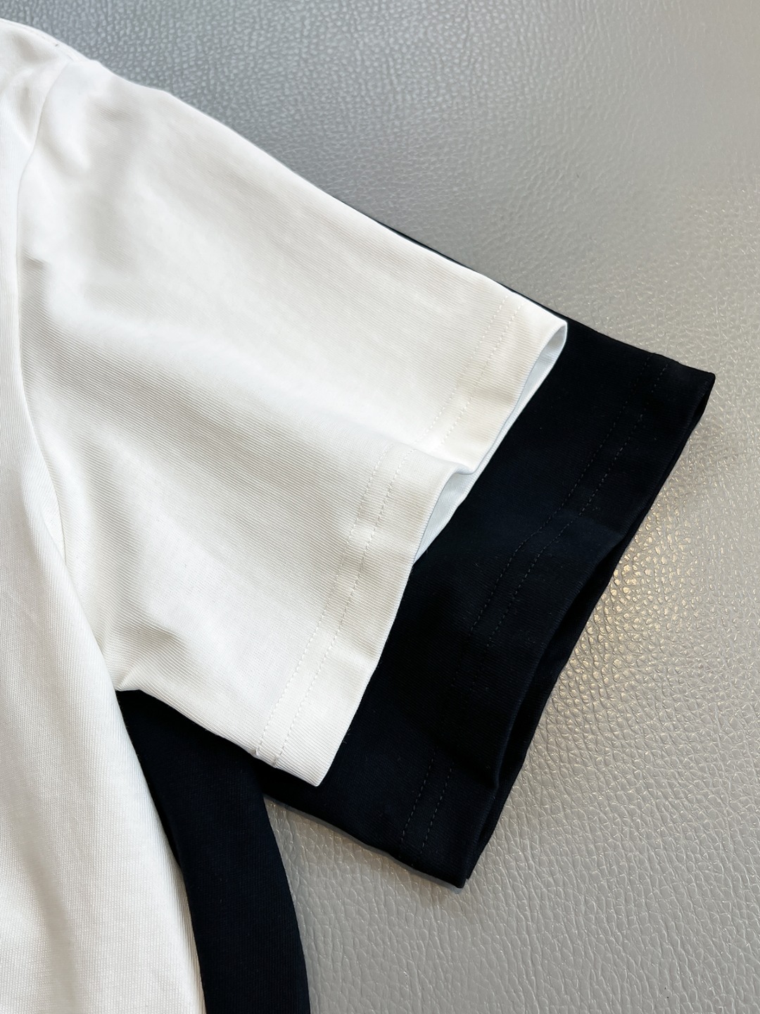 P120🍀【新品】贸易公司洋行货，重磅高级心水之物，2025春夏新款Di*r 手绘彩色标识印花男士短袖T恤。CD经典时髦字母风潮,凝聚独特技艺与灵巧的创意.简约而不失精炼风范…胸前Di*r 数码印花立体美观,后背Di*r 花卉印花,视觉效果彰显百态的奢华体验.平纹针织棉面料,细致工艺技术最高的面料标准.完美细腻的质感让着身更为舒适透气.现代休闲化裁剪工整细致,铸就独特造型魅力.
颜色：黑色 白色 
尺码：S M L XL XXL
尺码数据：
S码:胸围102cm-肩宽45cm-衣长69cm-袖长22cm
M码:胸围106cm-肩宽46cm-衣长70cm-袖长23cm
L码:胸围110cm-肩宽47cm-衣长71cm-袖长24cm
XL码:胸围114cm-肩宽48cm-衣长72cm-袖长25cm
XXL码:胸围118cm-肩宽49cm-衣长73cm-袖长26cm