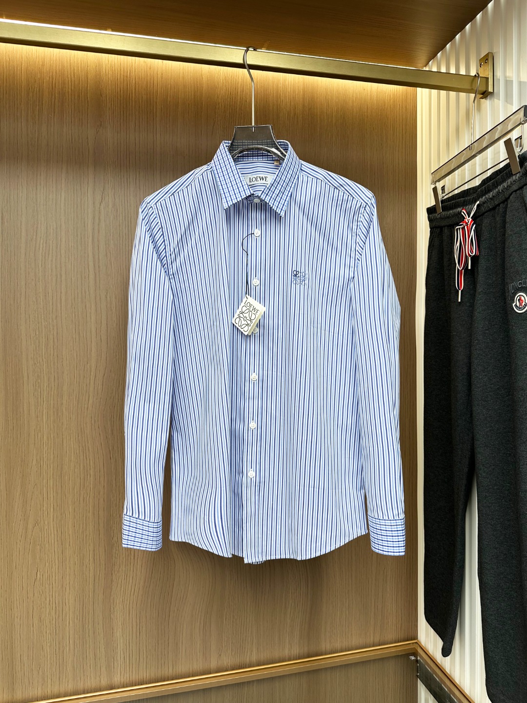 NO:681348,[New Product] Shanghai Trading Company order, 2025 early autumn new Lo*we Anagram embroidered logo original men's high-end business casual striped long-sleeved shirt. A typical Italian style fashion, very sophisticated in fabric selection and craftsmanship, very consistent with the LOW aesthetic tone, low-key and luxurious, elegant and noble. The logo on the hem of the body is a soul-like existence, presented in exquisite embroidery. This detail effectively flaunts the brand identity, enriches the vision and adds a sense of fashion!  As a recognized fashion item, the striped shirt is undoubtedly one of the most vital elements in the fashion circle. It has a high appearance rate, is simple and has a distinctive personality. It is a good medicine for improving vision. In terms of dressing, it is refreshing and age-reducing and has a sense of fashion. It is intellectually elegant and shows taste. It has various tags and symbols!  The fabrics and accessories of this shirt are all supplied by foreign customers, selected by the top Swiss ALUMO company. They are made of combed ultra-fine GIZA45 grade Egyptian cotton, 120 high-count double-ply imitation, and are treated with a no-iron process. The texture and comfort of the fabric have reached the peak, with excellent gloss, excellent skin-friendliness and breathability, and the texture reveals a sense of high-end luxury and gorgeousness!  The details are impeccable, exquisite and elegant, and the high-end quality is demonstrated everywhere. The top-grade mother-of-pearl buckles are selected with natural texture structure and are very ingenious. The plaid is naturally versatile and has a high mixing and matching space. It can be both business and leisure. It is a very high-end and high-quality shirt, which is rare but not sought after!  Color blue Size M L  XXL code: shoulder width 46.5cmcm - chest circumference 112cm - sleeve length 64.5cm - clothing length 78cm XXXL code: shoulder width 47.5cmcm - bust 116cm - sleeve length 65.5cm - clothing length 79cm,, shirts,19860909【新品】上海贸易公司订单,2025早秋新款Lo*we Anagram刺绣标识原单男士高端商务休闲条纹长袖衬衫.颇具意大利典型风格的时装,在面料选取和工艺方面都相当考究,极符合LOW美学基调,低调且奢华,优雅且高贵,衣身下摆处标识属于灵魂式的存在,以精美刺绣体呈现,此细节有力标榜了品牌身份,即丰富了视觉亦让时髦感加持！条纹衬衫作为公认的时尚单品,无疑是时尚圈生命力最强的元素之一,出镜率极高,简单而个性鲜明,是改良视觉的良药,在穿搭方面即清爽减龄又自带时髦感,即知性儒雅又彰显品位气质,有着各种标签符号！该款衬衫面料和辅料皆为外商客供,客供甄选的顶级瑞士ALUMO阿鲁姆公司,采用精梳超细的GIZA45等级埃及棉,120高支双股精仿而成,经过免烫工艺处理,面料质感与舒适度达到登峰造极,光泽度极好,亲肤性与透气性绝佳,肌理透着高级奢华感和华丽感！细节无可挑剔,精湛考究,处处彰显了高级品质感,甄选的顶级贝母扣,自带天然纹理构造,非常匠心,格子具有天生的百搭属性,混搭空间极高,商务休闲兼具,非常高端优质的一款衬衫,可遇而不可求！ 颜色蓝色 尺码M L XL XXL XXXL 尺码数据 M码:肩宽43.5cmcm-胸围100cm-袖长61.5cm-衣长75cm L码:肩宽44.5cmcm-胸围104cm-袖长62.5cm-衣长76cm XL码:肩宽45.5cmcm-胸围108cm-袖长63.5cm-衣长77cm XXL码:肩宽46.5cmcm-胸围112cm-袖长64.5cm-衣长78cm XXXL码:肩宽47.5cmcm-胸围116cm-袖长65.5cm-衣长79cm,,shirts,,Men's clothing