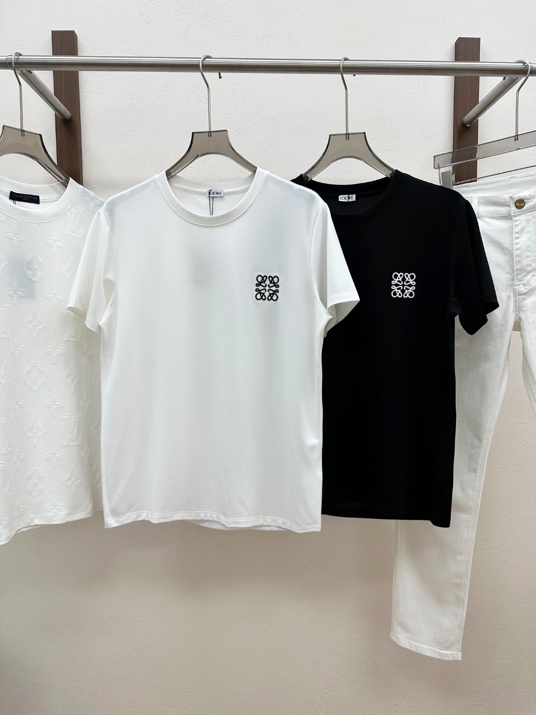 NO:830526,[New product] Rarely available through trading company channels, available simultaneously on the official website!  2026 spring and summer new Lo*we Anagram embroidered logo lightweight breathable stretch cotton men's and women's contrasting color three-dimensional logo embroidered casual pullover short-sleeved T-shirt!  This T-shirt is made of custom-made light elastic cotton, and its unique mesh structure on the surface is the designer's ingenuity!  These fine and regular meshes are like tiny ventilation holes, evenly distributed on the entire T-shirt. In the hot summer, when you wear it, you will feel like you are in a cool forest. The air can freely shuttle between the meshes, providing you with superior breathability, keeping you dry and comfortable at all times, away from the trouble of heat and sweat!  The classic contrasting color badge on the chest instantly becomes the visual focus!  The design adopts a classic contrasting color design. Two completely different but complementary colors collide with each other, creating a strong visual impact, which not only highlights the sense of fashion, but also maintains stability and grandeur!  The three-dimensional dense needle embroidery technology used to make this badge fully demonstrates the exquisite skills!  When you look closely, you can also see the delicate texture of the embroidery lines, the even stitch spacing and exquisite patterns, which all demonstrate the brand's persistent pursuit of quality!  The fit-fitting design can cleverly fit the body lines. It is neither too tight to make people feel restricted nor too loose to look dragging!  Wearing it, you will find that you seem to have been given a new temperament, with a taller and straighter posture and smoother lines!  Color White Black Size S M L  XXL size, shoulder width 49cm - bust 120cm - length 71cm, T-shirt, tees, t-shirt,19860909【新品】贸易公司渠道稀出,同步官网发售！2026春夏新款Lo*we Anagram刺绣标识轻薄透气弹力棉布男女同款对比色立体徽标刺绣休闲套头短袖T恤衫！这款T恤选用客供定制轻薄弹力棉布,其表面独特的网眼结构,更是设计师的匠心独运之处！这些细密而规则的网眼,如同一个个微小的透气孔,均匀地分布在整件T恤上,在炎炎夏日,当你穿上它,仿佛置身于清凉的森林之中,空气能够自由地在网眼间穿梭,为你提供优越的透气性,让你时刻保持干爽与舒适,远离闷热与汗水的困扰！胸前经典对比色徽章点缀,瞬间成为视觉焦点！设计上采用了经典对比色设计,两种截然不同却又相互映衬的颜色相互碰撞,产生出强烈的视觉冲击力,既彰显了时尚感,又不失稳重与大气！而制作这个徽章所采用的立体密针刺绣工艺,更是将精湛技艺展现得淋漓尽致！当你凑近仔细观察,还能看到刺绣线条的细腻纹理,那均匀的针距和精致的图案,无不彰显着品牌对品质的执着追求！合身版型设计,能够巧妙地贴合身体线条,既不会过于紧绷而让人感到束缚,也不会过于宽松而显得拖沓！穿上它你会发现自己仿佛被赋予了一种全新的气质,身姿更加挺拔,线条更加流畅！ 颜色白色 黑色 尺码S M L XL XXL 尺码数据 S码肩宽45cm-胸围104cm-衣长67cm  M码肩宽46cm-胸围108cm-衣长68cm  L码肩宽47cm-胸围112cm-衣长69cm  XL码肩宽48cm-胸围116cm-衣长70cm  XXL码肩宽49cm-胸围120cm-衣长71cm,,T-shirt,tees，t-shirt,,Men's clothing