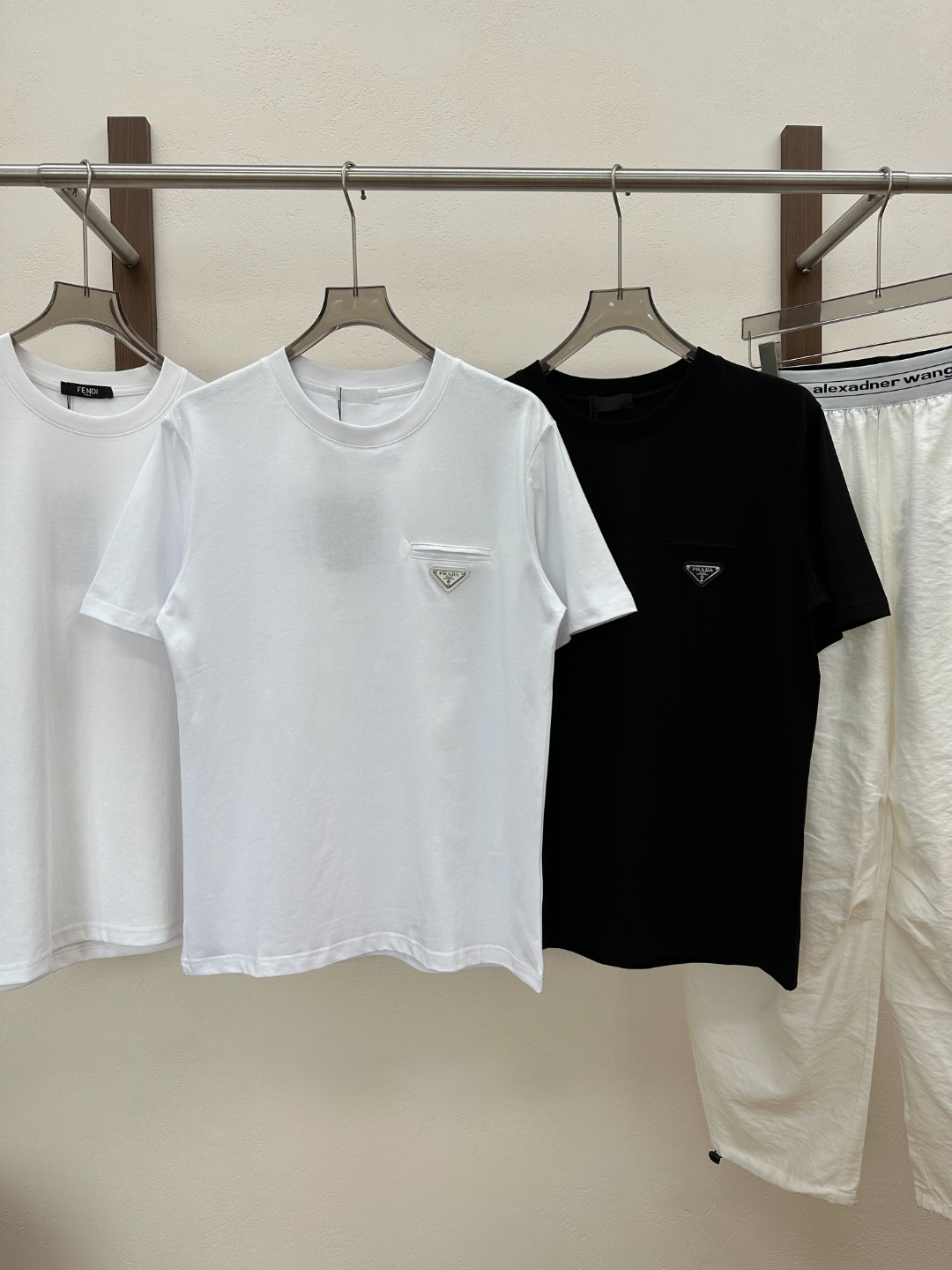 NO:830490,[New Product] 2026 Spring and Summer New Style Pr*da  Milano men's classic triangular logo unisex short-sleeved T-shirt. The micro-OS design tailoring has a personalized and fashionable style, creating the most elegant and simple fashion short T-shirt. Customer-supplied knitted cotton fabric, extraordinary texture experience, known as the most suitable cotton fabric for summer, light and breathable, and excellent comfort. Custom-woven rib collar design, flat fit and not easy to deform. PD base Milano logo badge still creates an alternative luxury fashion atmosphere. Color White Black Size S M L XL  XXL size data S size shoulder width 47cm - bust 104cm - dress length 68cm M size shoulder width 48cm - bust 108cm - dress length 69cm L size shoulder width 49cm - bust 112cm - dress length 70cm XL size shoulder width 50cm - chest 117cm - dress length 72cm  XXL size shoulder width 51cm - bust 122cm - length 74cm, T-shirt, tees, t-shirt,19860909【新品】2026春夏新款Pr*da Milano男士经典三角标标识男女同款短袖T恤.微OS设计裁剪兼具个性时尚范儿,铸就最为优雅简约的时尚短T.客供针织棉面料,非同一般的质感体验,号称最适合夏季的棉质面料,轻盈透气,舒适感极佳.定织型罗纹领口设计,平整服贴不易变形.PD基底Milano标识徽章依旧营造出另类的奢华时尚气息. 颜色白色 黑色 尺码S M L XL XXL 尺码数据 S码肩宽47cm-胸围104cm-衣长68cm M码肩宽48cm-胸围108cm-衣长69cm L码肩宽49cm-胸围112cm-衣长70cm XL码肩宽50cm-胸围117cm-衣长72cm XXL码肩宽51cm-胸围122cm-衣长74cm,,T-shirt,tees，t-shirt,,Men's clothing