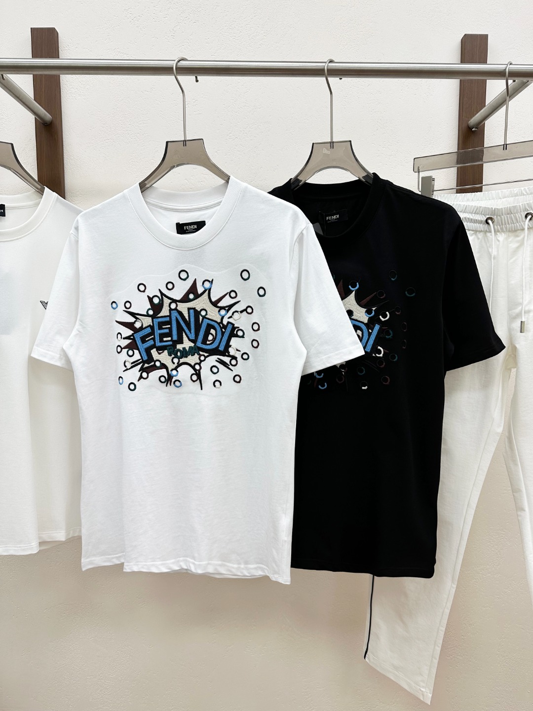 NO:830524,New Products] Trading company channels have released the new 2026 spring and summer Fe*di men's and women's casual short-sleeved T-shirts with explosion letter logo pattern embroidery!  This T-shirt is made of custom-made plain knitted cotton fabric. The fabric has excellent breathability and moisture absorption. Even in the hot summer, you will not feel the slightest stuffiness or discomfort when wearing it!  The front panel is the soul of the entire dress. Inspired by unique explosion elements, the designer skillfully interprets the interesting letter logo. Each letter seems to be inspired by the energy of the explosion, full of movement and vitality!  They are no longer boring symbols, but have become smart elves, jumping and playing on the T-shirt!  In order to create such a vivid and realistic effect, the designer used different embroidery threads for embroidery. The colors are rich and diverse, which instantly ignites people's visual nerves!  The use of dense embroidery technology has raised the quality of this T-shirt to a whole new level. Every stitch and thread are closely connected, without any slack or flaw!  The fit-fitting design is neither too loose to make you look bloated nor too tight to make you feel restrictive. This just-right version can perfectly fit the body curves and show off the wearer's figure advantages!  Color Black White Size S M L  XXL size, shoulder width 49cm - bust 116cm - length 73cm, T-shirt, tees, t-shirt,19860909新品】贸易公司渠道稀出2026春夏新款Fe*di男女同款爆炸字母标识图案刺绣休闲短袖T恤衫！这款T恤选用客供定制平纹针织棉布,面料具有极佳的透气性和吸湿性,即便在炎炎夏日,穿上它也不会感到丝毫的闷热与不适！前幅是整件衣服的灵魂所在,设计师以独特的爆炸元素为灵感,巧妙地演绎出趣味字母标识,那一个个字母仿佛是被爆炸的能量所激发,充满了动感与活力！它们不再是单调乏味的符号,而是变成了一个个灵动的精灵,在T恤上跳跃、嬉戏！为了打造出如此生动逼真的效果,设计师采用了不同绣线进行绣制,色彩丰富多样,瞬间点燃了人们的视觉神经！而密织刺绣工艺的运用,更是将这款T恤的品质提升到了一个全新的高度,每一针每一线都紧密相连,没有丝毫的松懈与瑕疵！合身版型设计,既不会过于宽松显得臃肿,也不会过于紧身让人感到束缚,这种恰到好处的版型能够完美地贴合身体曲线,展现出穿着者的身材优势！ 颜色黑色 白色 尺码S M L XL XXL 尺码数据 S码肩宽45cm-胸围100cm-衣长67cm  M码肩宽46cm-胸围104cm-衣长68cm  L码肩宽47cm-胸围108cm-衣长69cm  XL码肩宽48cm-胸围112cm-衣长71cm  XXL码肩宽49cm-胸围116cm-衣长73cm,,T-shirt,tees，t-shirt,,Men's clothing