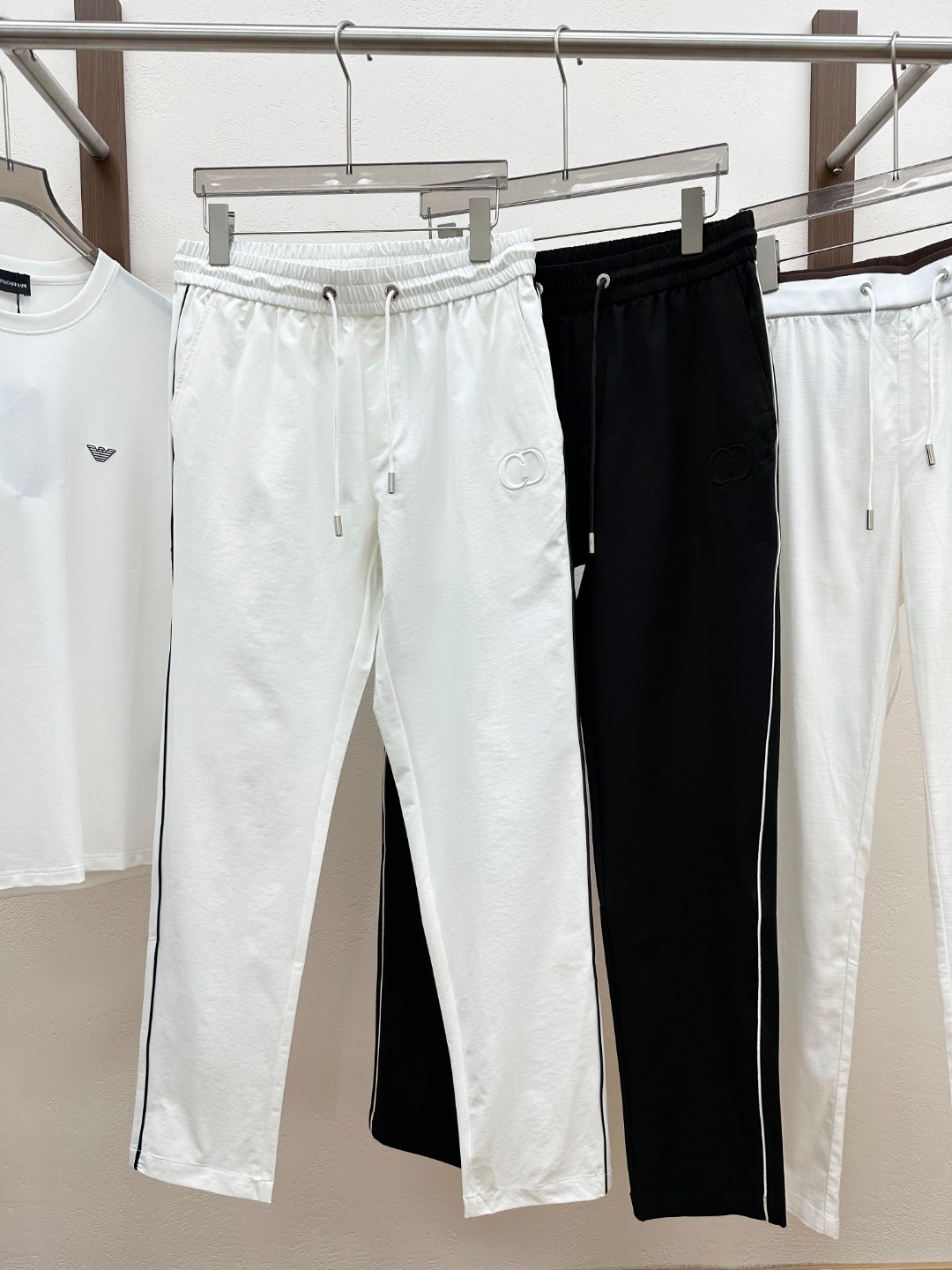 NO:830515,(Black without L) [New Product] Rarely released through trading company channels, 2026 spring and summer new D*or men’s three-dimensional embossed CD logo light woven cotton drawstring fashionable casual trousers!  The trousers are made of custom-made light woven cotton. It is not only as smooth as silk, but also has the unique skin-friendly properties of cotton. When worn close to the body, it is like being gently wrapped by a layer of soft clouds without any itch!  Moreover, the breathability of this light and thin fabric is outstanding. In the hot summer, when others are troubled by the heat and sweat, you can feel the slightest coolness when wearing these pants. The air can freely shuttle between the fabrics, quickly expelling the heat and moisture from the body, keeping you dry and comfortable at all times, as if you are in a cool forest!  The three-dimensional embossed CD logo decoration on the front panel is definitely the finishing touch!  It protrudes high on the pants, as if it is a carefully carved work of art, and every detail is handled just right!  From the smoothness of the lines to the three-dimensional sense of the relief, they all demonstrate the brand's high-end quality and unique design concept!  The two sides of the pants are also decorated with contrasting piping. This design adds liveliness and agility to the whole!  The drawstring elastic waistband design fully considers the needs of people with different body shapes. Whether you are a slim fashionista or a person with a plump figure, you can easily control it!  The drawstring design is very user-friendly, you can freely adjust the tightness of the waistband according to your own preferences and comfort!  This flexible design allows you to find the most suitable way of wearing it on different occasions, truly achieving the perfect combination of fashion and comfort!  The straight cut design is simple and elegant, which can well modify the leg lines and make your legs look straighter and slender!  Color Black White Size M L  XL size waist 84/88cm - hip 106cm - front 29cm - thigh 62cm - trouser length 102cm - trouser leg 36cm XXL size waist 88/92cm - hip 110cm - front 30cm - thigh 64cm - trouser length 103cm - trouser leg 37cm  3XL size waist 92/96cm - hip 114cm - front 30cm - thigh 66cm - trouser length 104cm - trouser leg 38cm,,19860909（黑色无L）【新品】贸易公司渠道稀出,2026春夏新款D*or男士立体浮雕CD徽标轻薄梭织棉布抽绳时尚休闲长裤！该裤装采用客供定制轻薄梭织棉布,它不仅有着丝绸般的顺滑,还具备棉布特有的亲肤性,贴身穿在身上,就像被一层轻柔的云朵温柔包裹,没有丝毫的刺痒感！而且这种轻薄面料的透气性堪称一绝,在炎炎夏日,当别人被闷热和汗水困扰时,穿上这条裤子的你却能感受到丝丝凉意,空气能够自由地在面料间穿梭,将身体的热气和湿气迅速排出,让你时刻保持干爽舒适,仿佛置身于清凉的森林之中！前幅立体浮雕CD徽标装饰,绝对是点睛之笔！它高高凸起于裤面,仿佛是精心雕琢的艺术品,每一个细节都处理得恰到好处！从线条的流畅度到浮雕的立体感,都彰显着品牌的高端品质和独特设计理念！裤子两侧还采用了撞色滚边装饰,这一设计为整体增添了一份活泼与灵动！抽绳松紧裤腰设计,充分考虑了不同身材人群的需求,无论你是身材苗条的时尚达人,还是身材较为丰满的个性人士,都能轻松驾驭！抽绳的设计非常人性化,你可以根据自己的喜好和舒适度自由调节裤腰的松紧程度！这种灵活多变的设计,让你在不同的场合都能找到最适合自己的穿着方式,真正实现了时尚与舒适的完美结合！直筒版型裁剪设计简洁大方,能够很好地修饰腿部线条,让你的双腿看起来更加笔直修长！ 颜色黑色 白色 尺码M L XL XXL XXXL 尺码数据 M码腰围76/80cm-臀围98cm-前档28cm-大腿围60cm-裤长100cm-裤脚34cm L码腰围80/84cm-臀围102cm-前档29cm-大腿围61cm-裤长101cm-裤脚35cm XL码腰围84/88cm-臀围106cm-前档29cm-大腿围62cm-裤长102cm-裤脚36cm XXL码腰围88/92cm-臀围110cm-前档30cm-大腿围64cm-裤长103cm-裤脚37cm 3XL码腰围92/96cm-臀围114cm-前档30cm-大腿围66cm-裤长104cm-裤脚38cm,,,Men's clothing